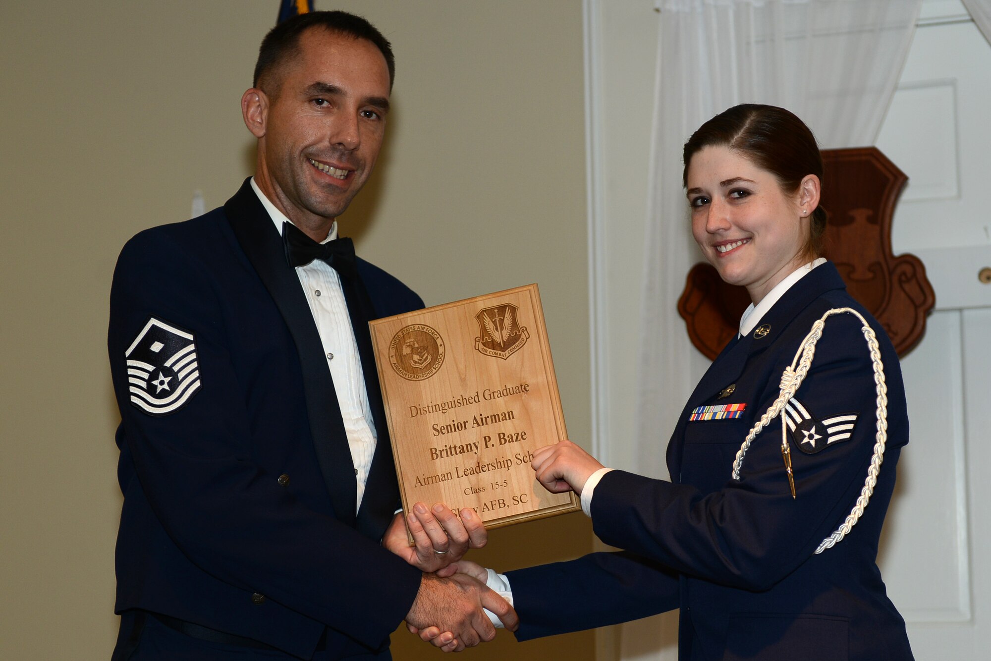U.S. Air Force Senior Airman Brittany Baze, 3rd Intelligence Squadron, receives a distinguished graduate award for the Senior Master Sgt. David B. Reid Airman Leadership School Class 15-5 from Master Sgt. Robert Finton, 20th Operations Support Squadron first sergeant, at Shaw Air Force Base, S.C., July 2, 2015. The distinguished graduate awards are given to the top 10 percent of the class for total point accumulation. (U.S. Air Force photo by Senior Airman Diana M. Cossaboom/Released)