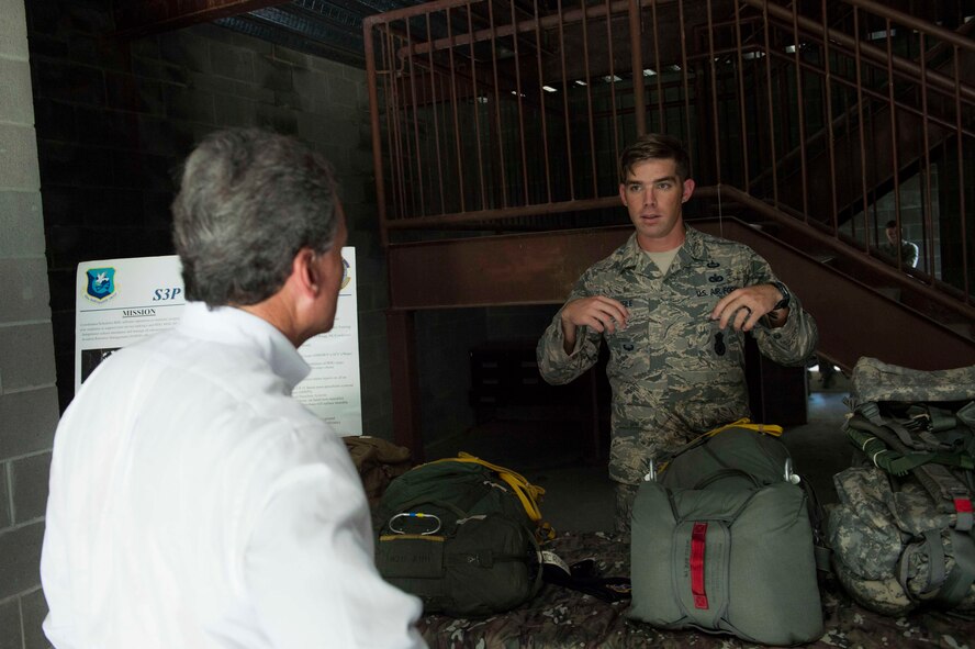 U.S. Air Force Staff Sgt. Steven Trimble, right, 820th Combat Operations Squadron jumpmaster, explains proper parachute wear to U.S. Rep. Buddy Carter of Georgia, during a base tour July 2, 2015, at Moody Air Force Base, Ga. Carter viewed a static-line jump before speaking to the jumpmaster. (U.S. Air Force photo by Airman 1st Class Dillian Bamman/Released)