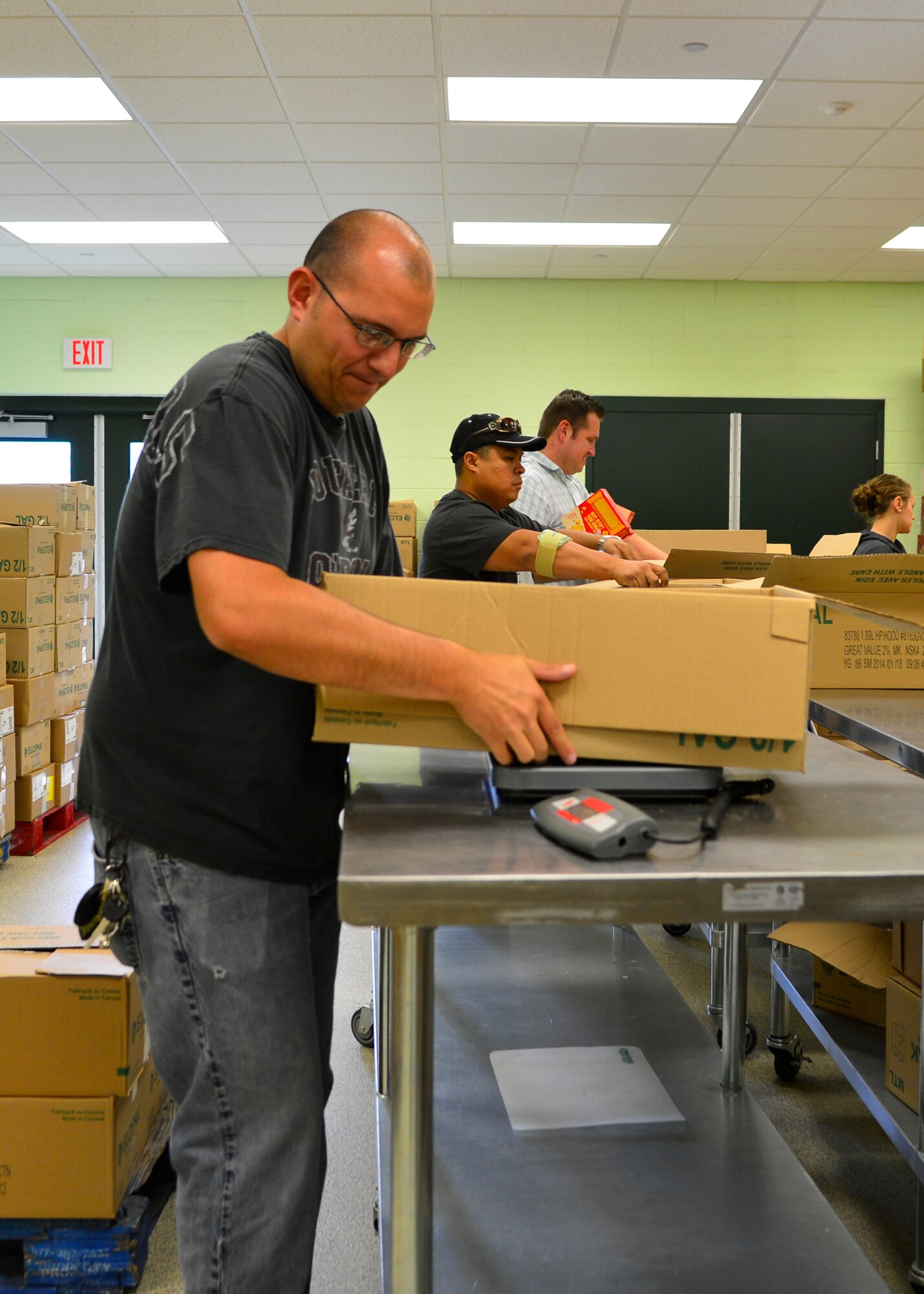 Staff Sgt. Craig Struck, 436th Maintenance Operations Quality Training Program instructor, weighs a box of canned soups July 6, 2015, at the Food Bank of Delaware in Milford, Del. Team Dover Airmen sorted and boxed more 3,500 pounds of donated food to be distributed throughout Delaware to various food distribution centers. (U.S. Air Force photo/Airman 1st Class William Johnson)
