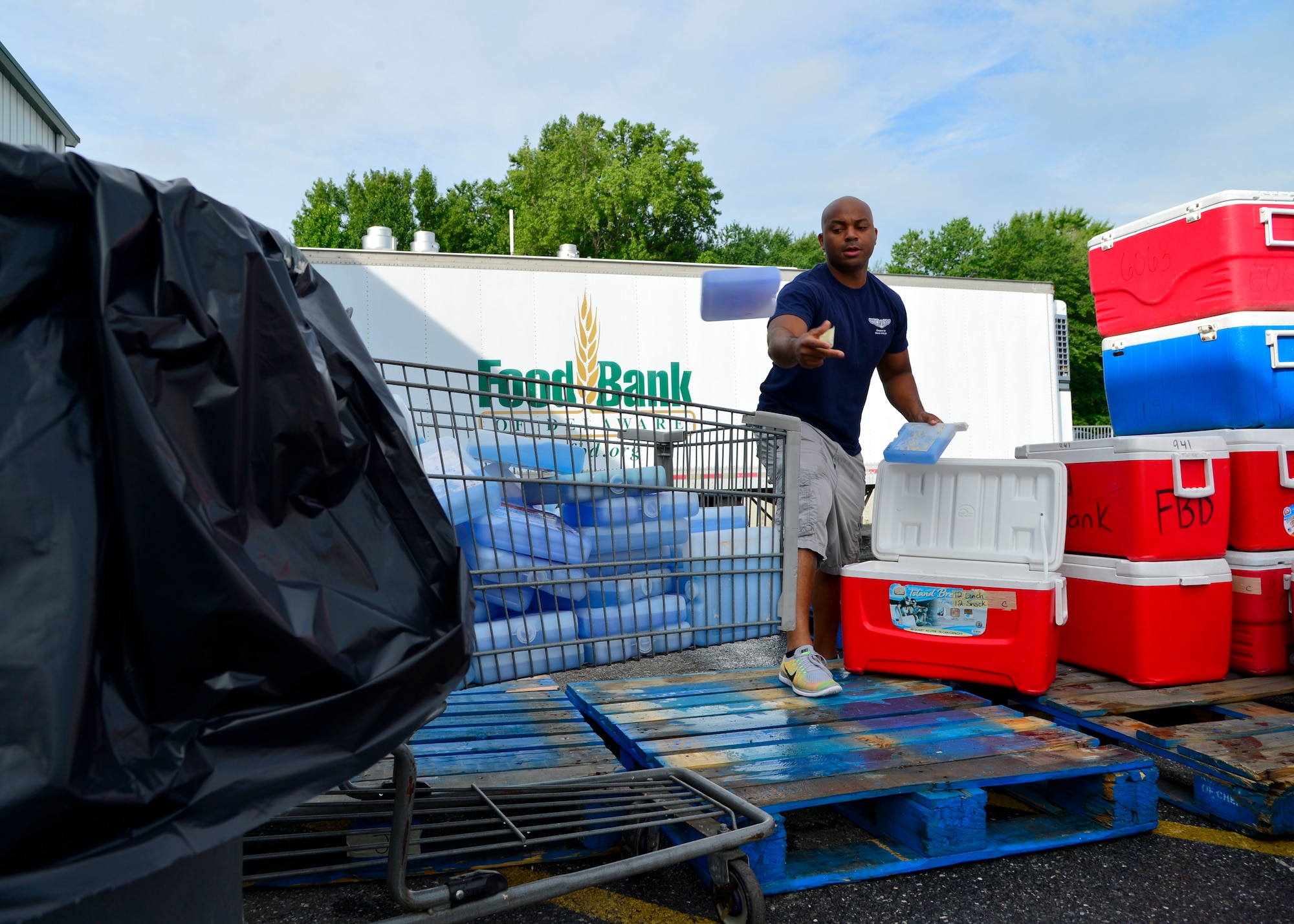 Master Sgt. Jamie Beard, 436th Maintenance Operations first sergeant, tosses ice packs out of coolers before being cleaned July 6, 2015, at the Food Bank of Delaware in Milford, Del. The coolers are used to distribute meals in the After-School Nutrition Program and Summer Nutrition Program. (U.S. Air Force photo/Airman 1st Class William Johnson)