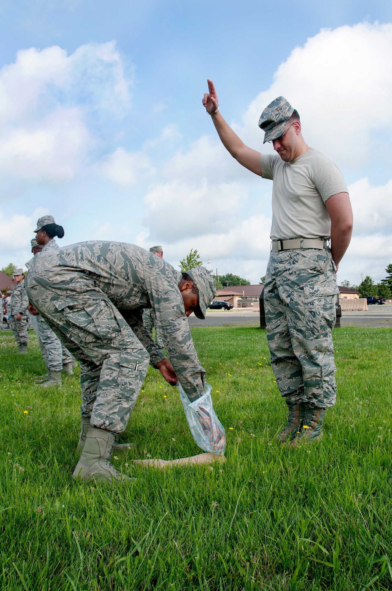Airman 1st Class John Adams picks up a limb when Staff Sgt. Vincent Del Priore raises his hand after locating it during an exercise at the 108th Force Support Squadron's annual home-station training at Joint Base McGuire-Dix-Lakehurst, N.J., July 7, 2015. The training helped prepare Airmen to search and recover scattered remains over an area if a disaster took place, such as a plane crash. (U.S. Air National Guard photo by Airman 1st Class Julia Pyun/Released)