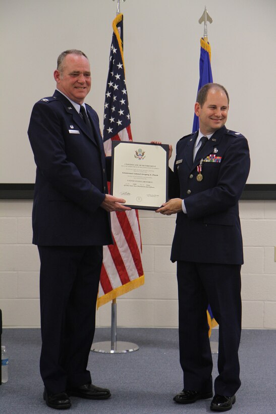 Commander of the 932nd Maintenance Group, Col. James McDonnell (left), presents a certificate of retirement from the armed forces of the United States that certifies that Lieutenant Colonel Gregory Plank has served faithfully and honorably and was retired from the United States Air Force in a ceremony held recently.  (U.S. Air Force photo)