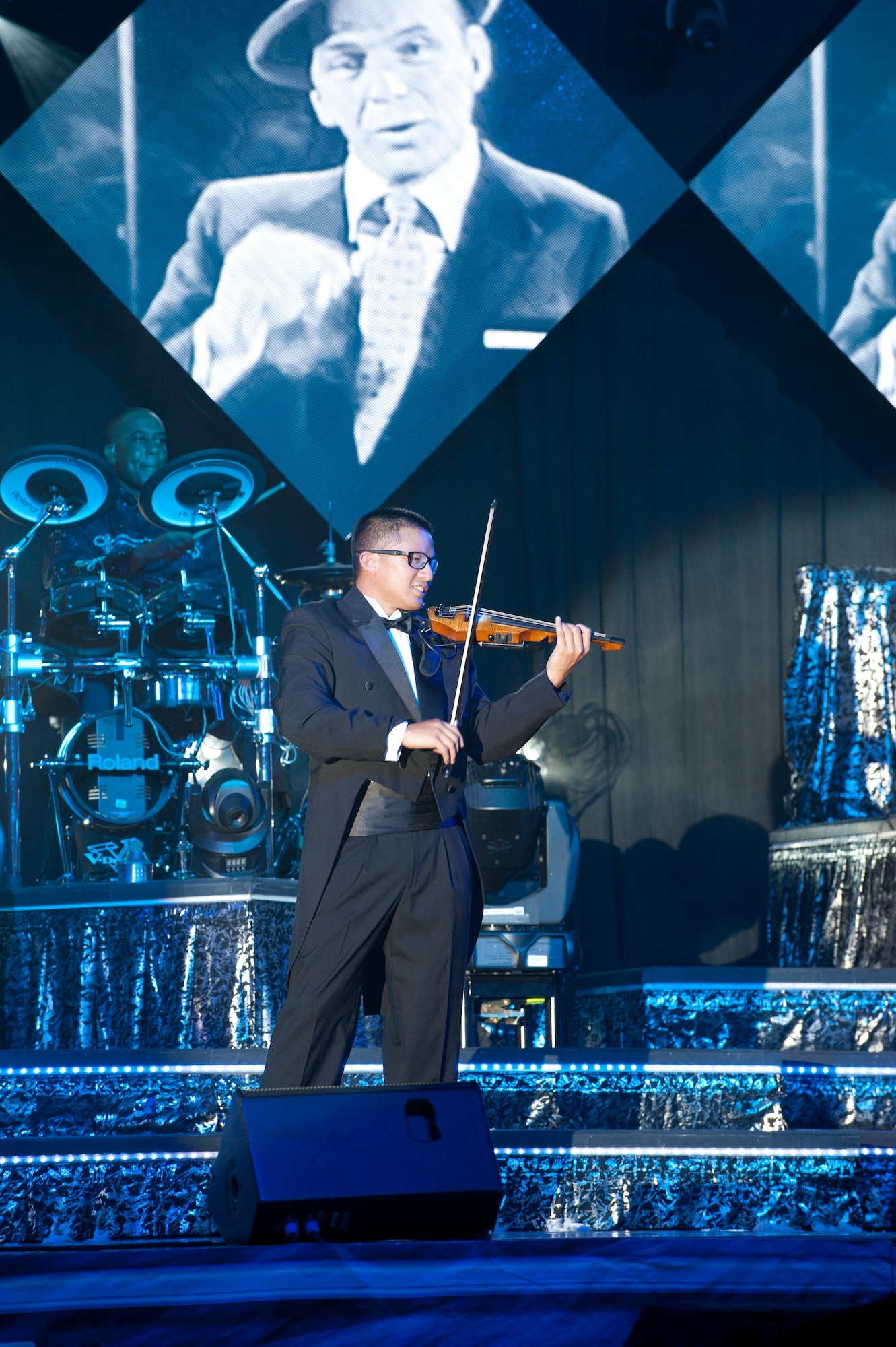 PETERSON AIR FORCE BASE, Colo. – 1st Lt. Oliver Chang, Tops in Blue flight chief and violinist, entertains the crowd during the Tops in Blue performance at Hangar 140, July 1, 2015. The team of active duty performers serve as an expeditionary entertainment unit to provide quality entertainment from within the Air Force to Airmen across the globe, while promoting community relations, supporting recruiting efforts and serving as ambassadors for the United States of America. (U.S. Air Force photo by Airman 1st Class Rose Gudex)