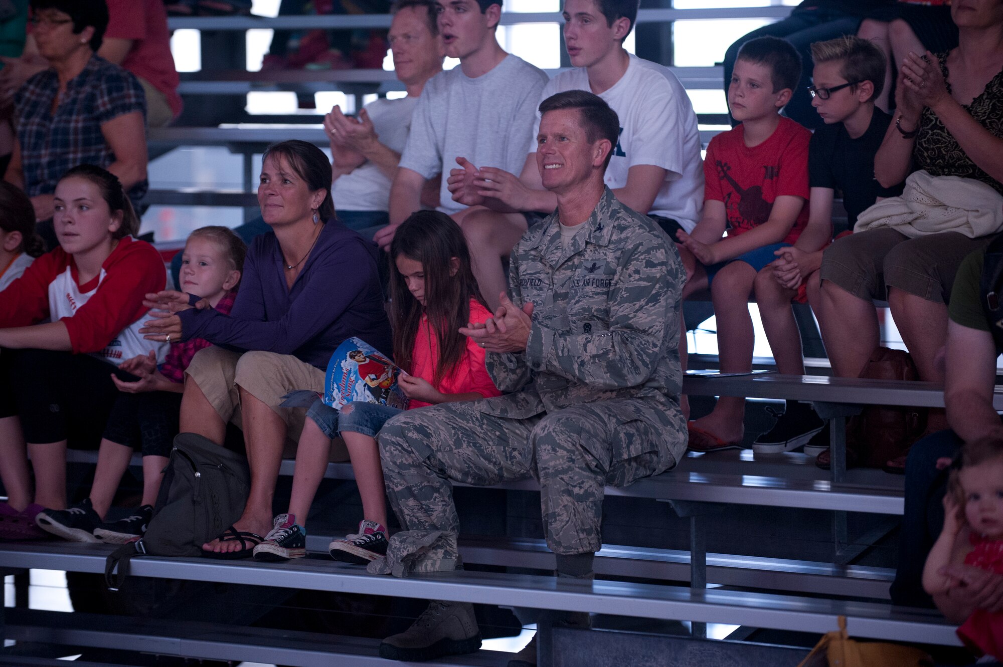 PETERSON AIR FORCE BASE, Colo. – Col. Richard Burchfield, 21st Space Wing senior individual mobilizations augmentee, and his family attend the Tops in Blue performance at Hangar 140, July 1, 2015. The Tops in Blue performers travel to 20 countries putting on 75 shows in seven months promoting community relations, recruiting efforts and serving as ambassadors for the United States of America and the U.S. Air Force. (U.S. Air Force photo by Airman 1st Class Rose Gudex)