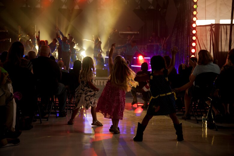 PETERSON AIR FORCE BASE, Colo. – Children dance in the aisle during the Tops in Blue performance at Hangar 140, July 1, 2015. The Tops in Blue performers travel to 20 countries putting on 75 shows in seven months, promoting community relations, recruiting efforts and serving as ambassadors for the United States and the U.S. Air Force. (U.S. Air Force photo by Senior Airman Tiffany DeNault)