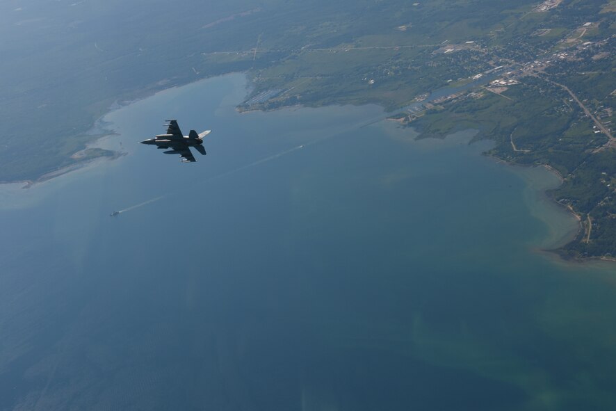 U.S. Air Force Capt. Roy Poor, an F-16 Fighting Falcon pilot, flies over the Mackinac Bridge and Mackinac Island during a training sortie June 26, 2015. The 180th Fighter Wing was performing multiple training sorties over Lake Huron and Northern Michigan June 21-24. (Air National Guard photo by Tech. Sgt. Amber Williams/Released)