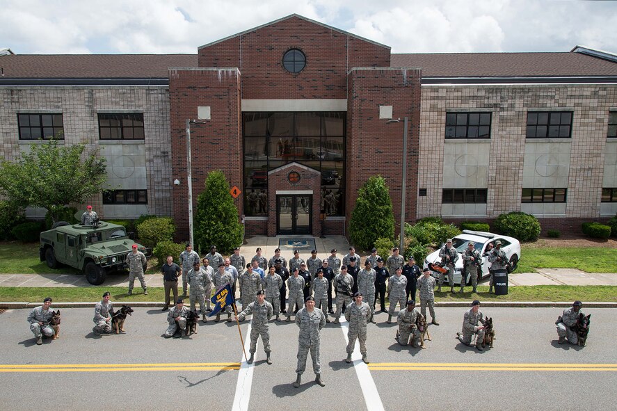Members of the 66th Security Forces Squadron, led by the Commander Lt. Col. Michael J. Morales, stand in formation July 7 for a group photo on base. The squadron was notified earlier this spring that it was selected as the 2014 Air Force Outstanding Security Forces Unit in the small unit category. (U.S. Air Force photo by Mark Herlihy)