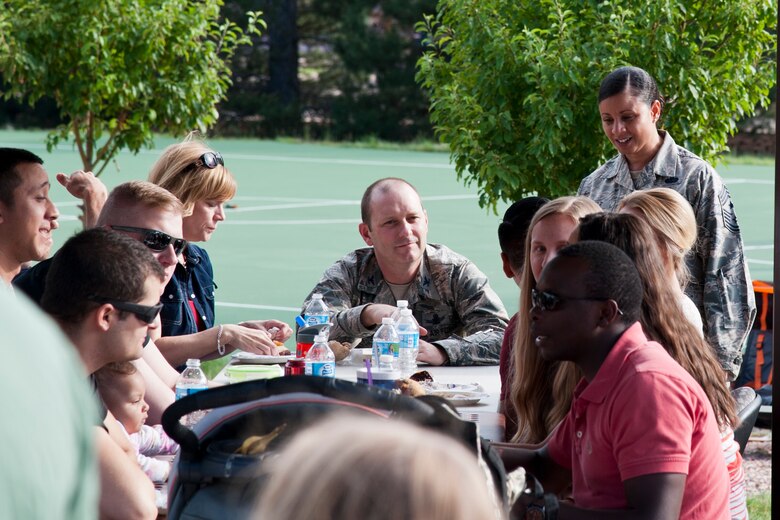 PETERSON AIR FORCE BASE, Colo. – Col. Douglas Schiess, 21st Space Wing commander, his wife Debbie and Chief Idalia Peele, 21st Space Wing command chief, get to know Team Pete members at the Peterson Chapel’s community cook out at the Terra Vista community center, July 2, 2015. Approximately 200 Peterson members and their families came out to enjoy the grilled food, games and music before the start of the July Fourth weekend. (U.S. Air Force photo by Senior Airman Tiffany DeNault)