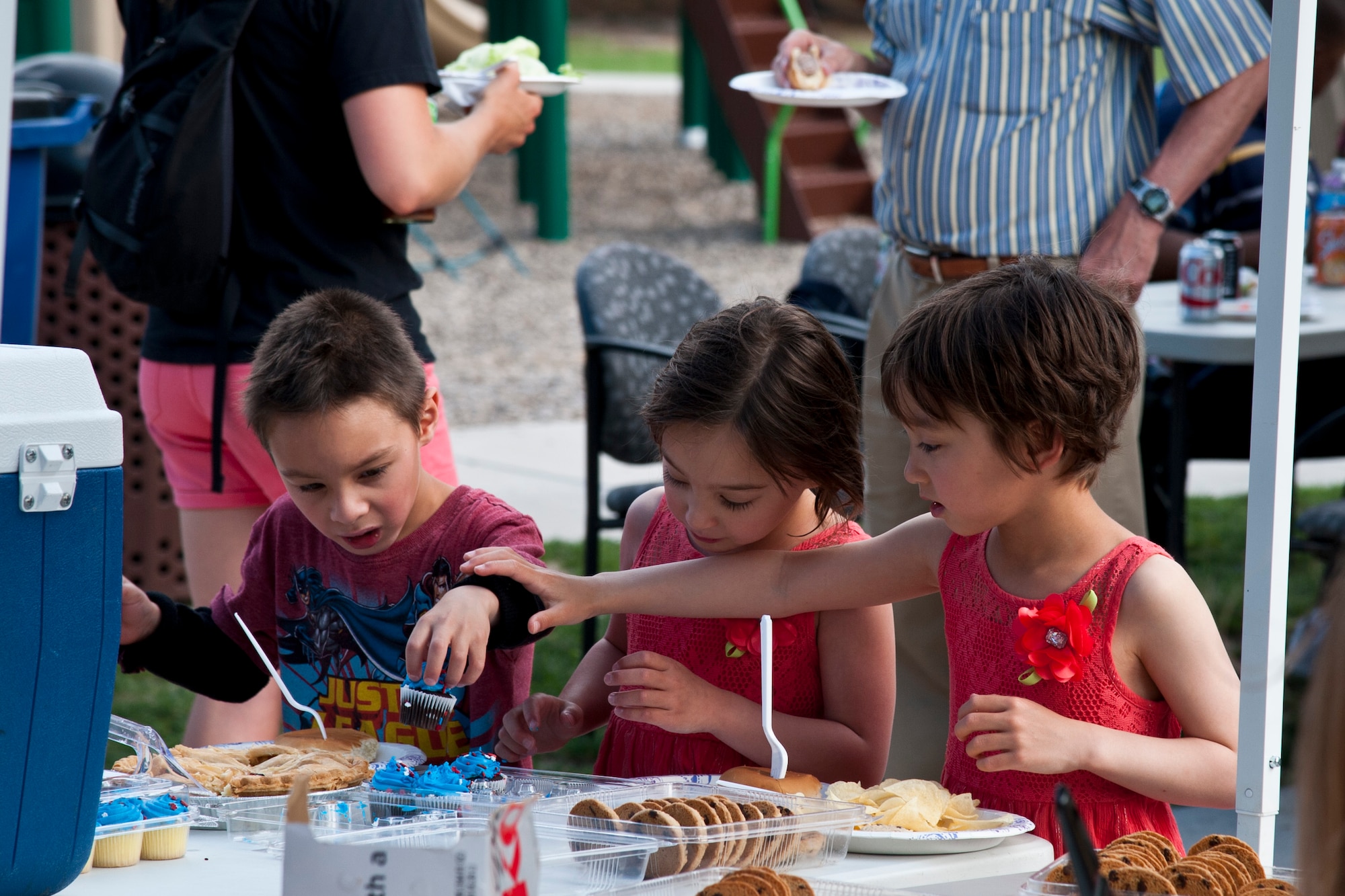 PETERSON AIR FORCE BASE, Colo. – Ethan, Sophia and Amelia Westerberg help themselves to a couple miniature cupcakes during the Peterson Chapel’s community cook out at the Terra Vista community center, July 2, 2015. The Chapel provided the grilled food, games and music to approximately 200 Pete members and families. (U.S. Air Force photo by Senior Airman Tiffany DeNault)