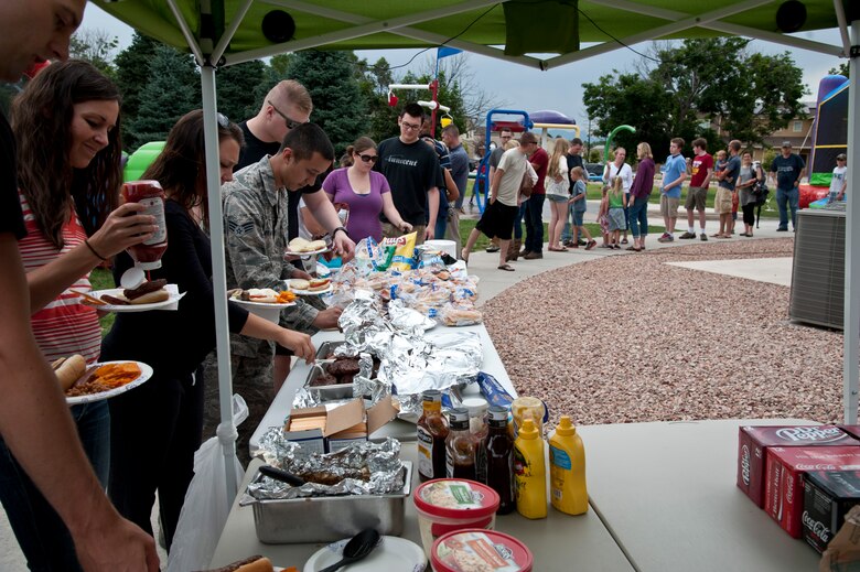 PETERSON AIR FORCE BASE, Colo. – Members of Peterson and their families help themselves to hamburgers and hot dogs during the Peterson Chapel’s community cook out at the Tierra Vista community center, July 2, 2015. The Chapel kicked off the July Fourth weekend with approximately 200 people with grilled food, games and music. (U.S. Air Force photo by Senior Airman Tiffany DeNault)