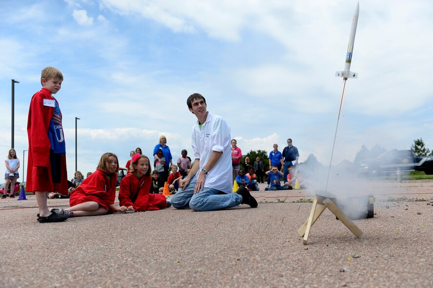 Schriever School Age Program students McKinley Cross (left), Kayden Rice and Hannah Withycombe launch the rocket they built, while Monahan LLC Science Camp staff member Sam Birchenough supervises, Thursday July 2, 2015 at Schriever Air Force Base, Colorado. The rocket launch culminated the SAPs Science Camp week, where, as part of a mock meteorite strike, students also learned about the scientific method to create a theory and hypothesis for the strike, built robots to collect data in a radioactive environment and dissected frogs to check for infections in the environment. (U.S. Air Force photo/Christopher DeWitt)