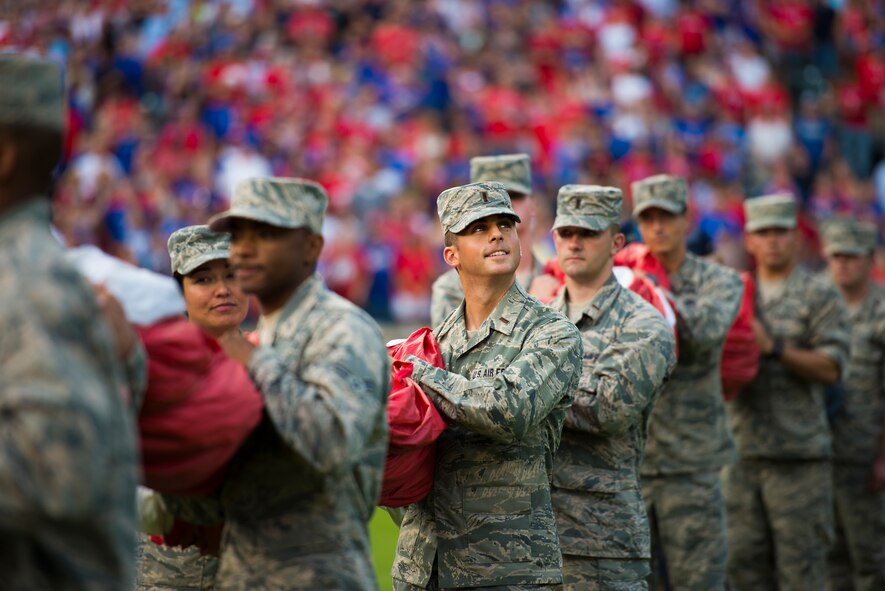 U.S. Air Force 2nd Lt. Tyler Almquist, student at Sheppard Air Force Base, Texas, helps hold a giant U.S. Flag for an enlistment ceremony during the opening of the Rangers game in Arlington, Texas, July 4, 2015. More than 60 Airmen from Sheppard volunteered with the 344th Recruiting Squadron to help unfurl the flag for approximately 150 new Air Force enlistees who swore-in during the game. (U.S. Air Force photo by Senior Airman Kyle Gese/Released)