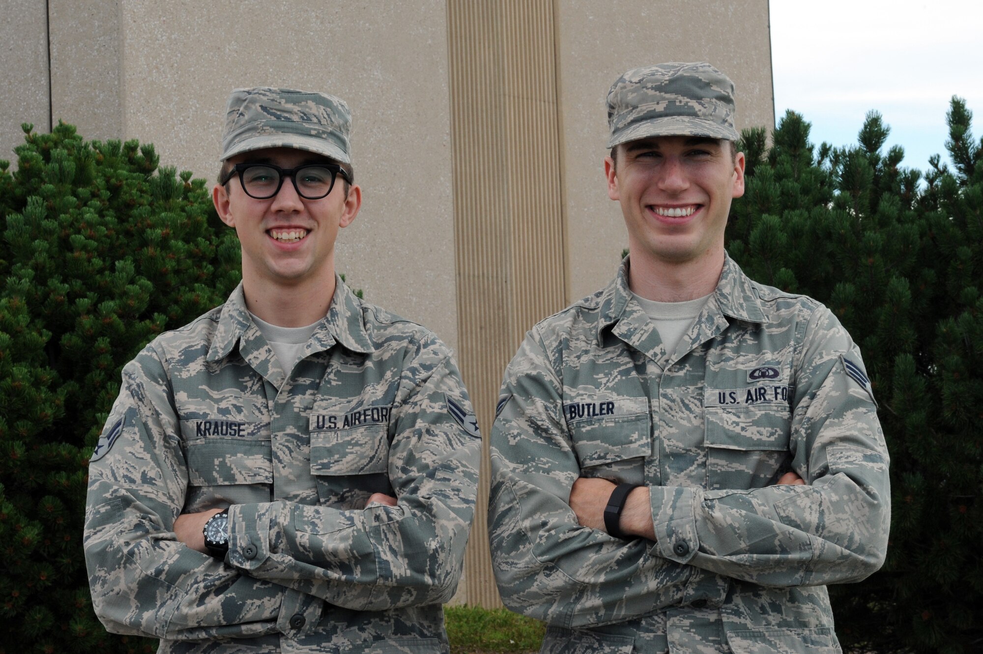 Airman 1st Class Grant Krause and Senior Airman Spencer Butler, 28th Operations Support Squadron air traffic controllers, stand in front of the air traffic control tower at Ellsworth Air Force Base, S.D., June 24, 2015. Krause and Butler rescued three animals from an apartment fire in Rapid City, S.D., June 20. (U.S. Air Force photo by Senior Airman Hailey R. Staker/Released)