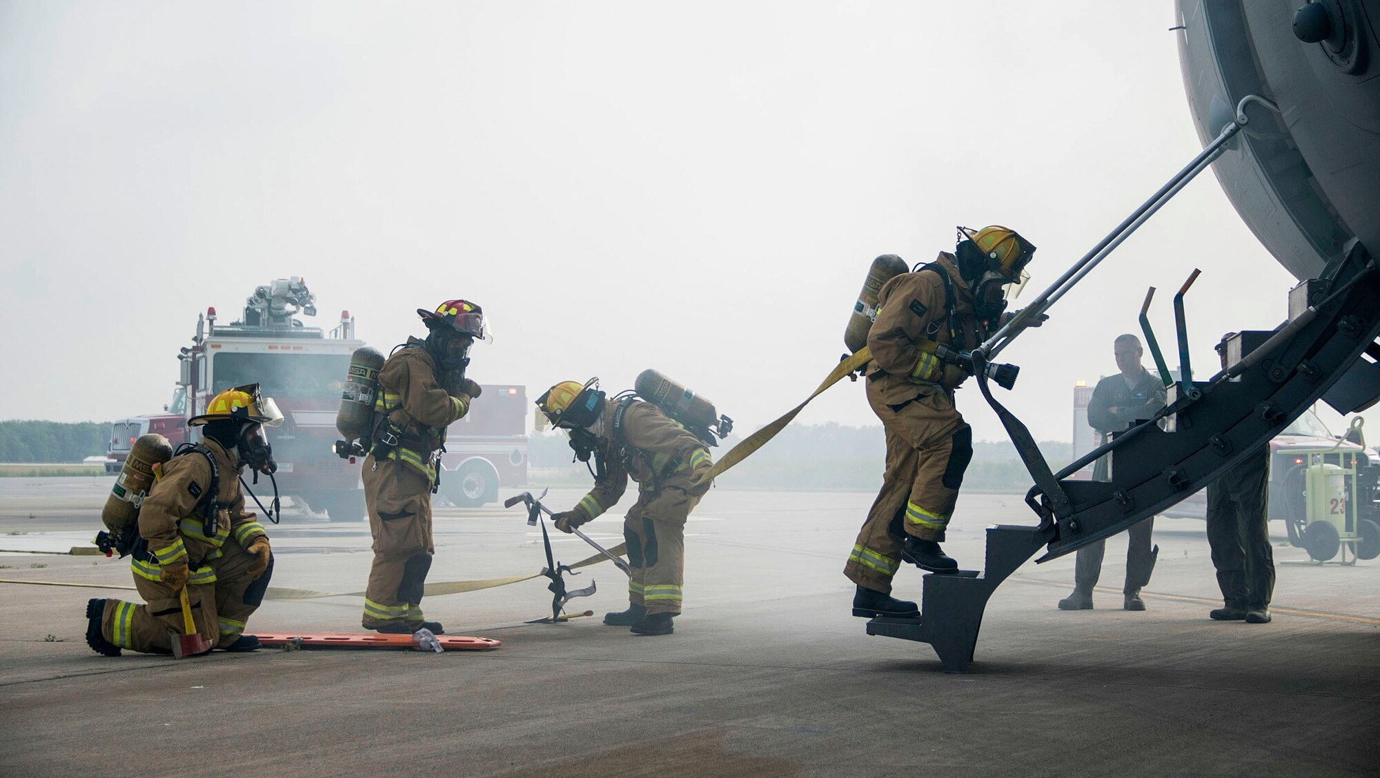 TOLEDO, Ohio - Firefighters assigned to the 180th Fire Department assess a simulated fire on board a C-17 Globemaster III during a training exercise here June 7, 2015. The exercise, which took place June 4-7, 2015, brought together: the Air National Guard, Air Force Reserve, Army Reserve, Navy Reserve, U.S. Special Operations Command, U.S. Customs and Border Patrol, the Toledo Police Department, and other local police and fire departments who observed the activities. (U.S. Air Force photo/Senior Airman Devin Long)