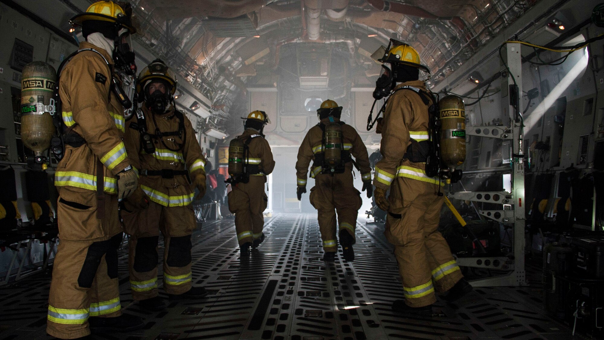 TOLEDO, Ohio - Firefighters assigned to the 180th Fire Department assess a simulated fire in the cargo area of a C-17 Globemaster III during a training exercise here June 7, 2015. The exercise, which took place June 4-7, 2015, brought together: the Air National Guard, Air Force Reserve, Army Reserve, Navy Reserve, U.S. Special Operations Command, U.S. Customs and Border Patrol, the Toledo Police Department, and other local police and fire departments who observed the activities. (U.S. Air Force photo/Senior Airman Devin Long)