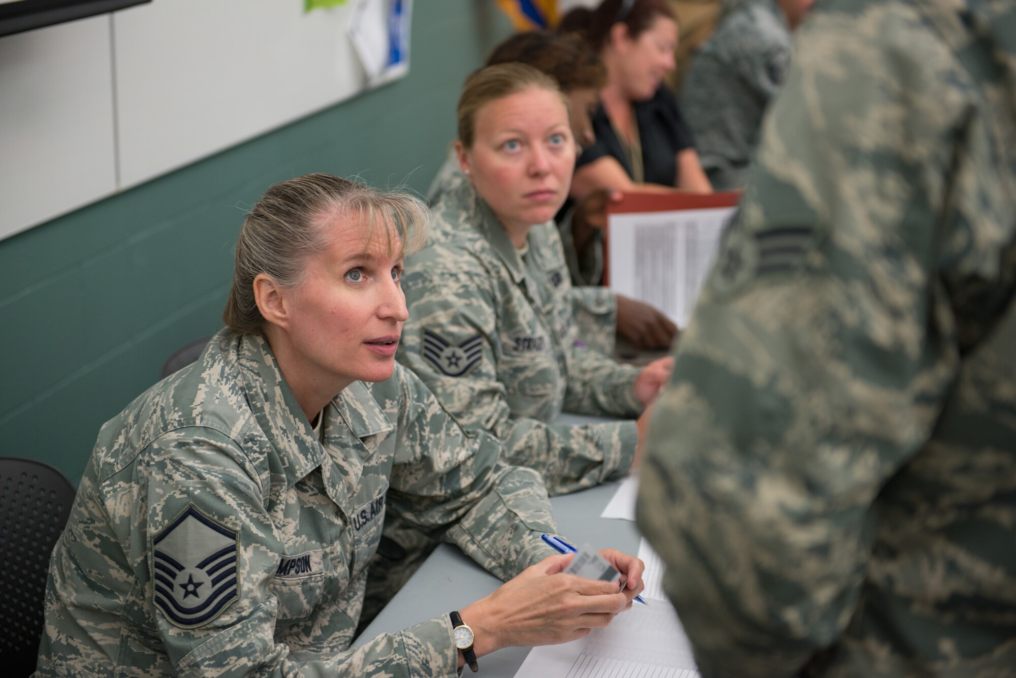 Master Sgt. Becky Thompson and Staff Sgt. Kandi Stragey, 934th Force Support Squadron, answer questions from deploying Airmen in the 934th Security Forces Squadron.  Members of the 934 SFS receive briefings and complete a personnel deployment function line making sure everything is in order as they leave for their upcoming mission to Southwest Asia.  (U.S. Air Force photo by Shannon McKay/Released)