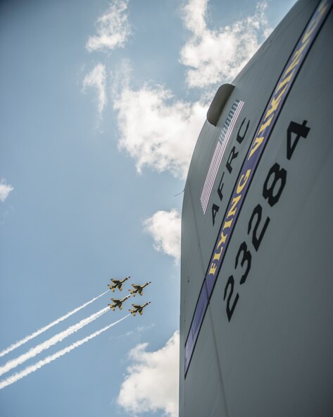 The U.S. Air Force Thunderbirds perform a 4-ship diamond formation fly over above the tail flash of a 934th Airlift Wing C-130 aircraft.  The aerial demonstration and static tours were part of the Minnesota Air Spectacular in Mankato, Minn., June 27-28, highlighting many different aircraft.  (U.S. Air Force photo by Shannon McKay/Reserved)