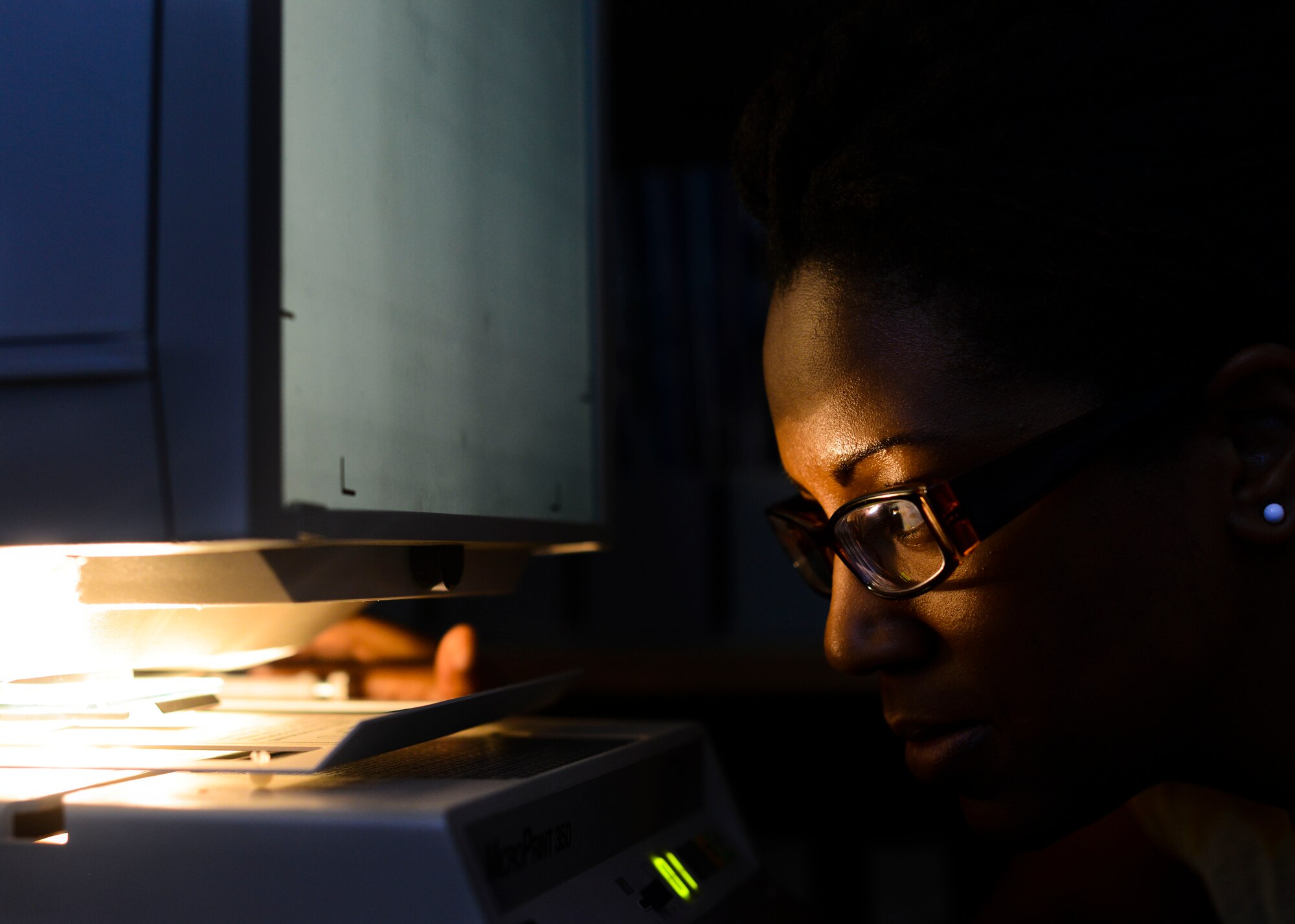 Aungelic Nelson, 31st Fighter Wing historian, adjusts a tape on a microfiche tape reader, July 7, 2015, at Aviano Air Base, Italy. Historians collect, archive and access documented work, such as old maps, policy letters and morale items for referential use. (U.S. Air Force Senior Airman Austin Harvill/Released)
