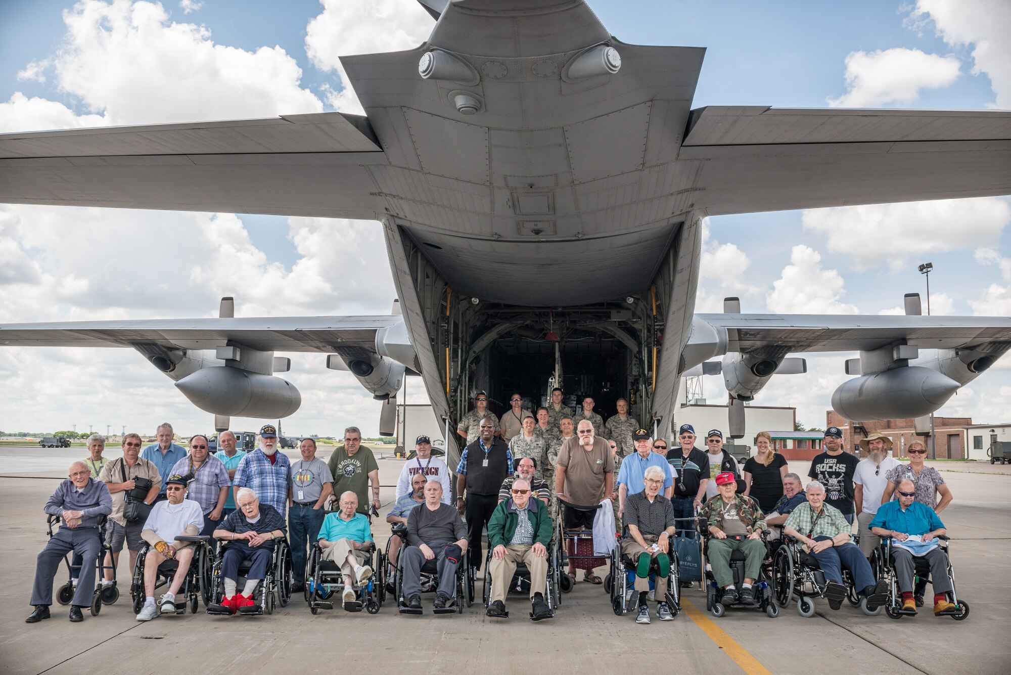934th Airlift Wing Airmen and residents of the Minnesota Veterans Homes in Minneapolis and Hastings pose for a group photo by a C-130 aircraft during the annual Take a Vet to Lunch.  Veterans join members of the 934 AW for an afternoon of lunch, conversation, camaraderie, and a tour at the Minneapolis-St. Paul Air Reserve Station, Minn.  (U.S. Air Force photo by Shannon McKay/Released)