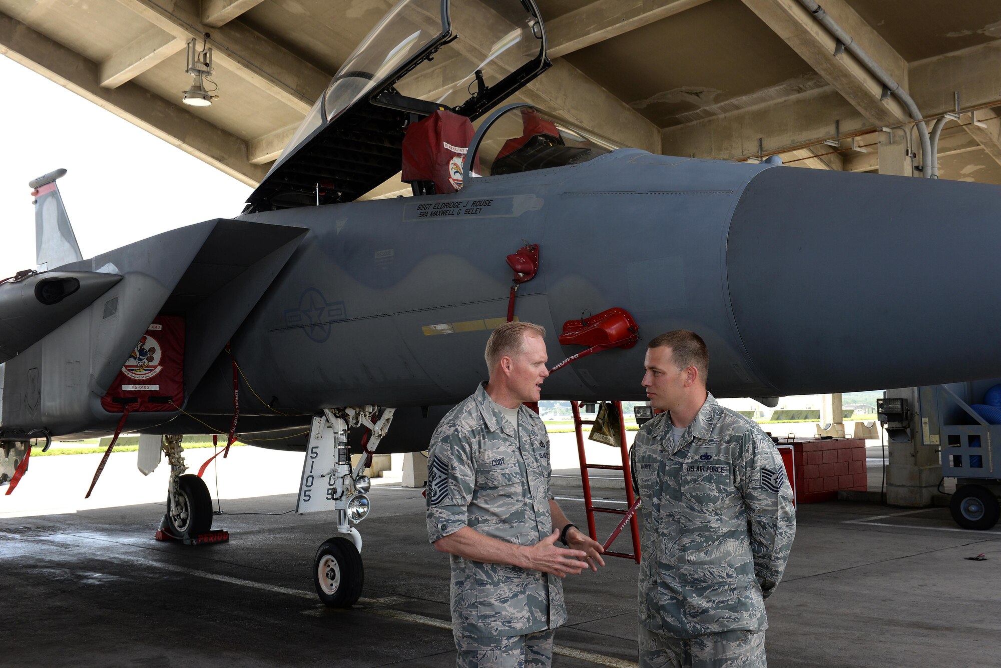 Chief Master Sgt. of the Air Force James Cody congratulates U.S. Air Force Tech. Sgt. Robert Marcy, 18th Component Maintenance Squadron production supervisor, for his hard work and the impact he has on the Air Force in front of a U.S. Air Force F-15 Eagle on Kadena Air Base, Japan, July 7, 2015. While on Kadena, Cody spoke face-to-face with enlisted personnel that made up Team Kadena. (U.S. Air Force photo by Senior Airman Omari Bernard)