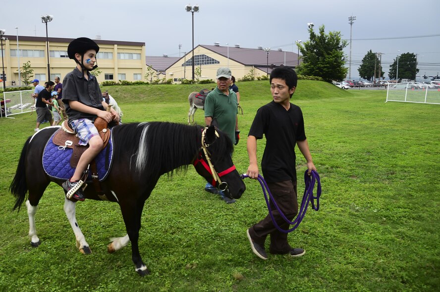 Radek Hungler, 9, son of David Hungler, 374th Office of Special Investigations special agent, rides a pony during the Celebrate America event at Yokota Air Base, Japan, July 2, 2015. The annual event provided military members and their families the opportunity to enjoy games, food and bands before culminating in a fireworks display to celebrate Independence Day. (U.S. Air Force photo by Senior Airman David Owsianka/Released)