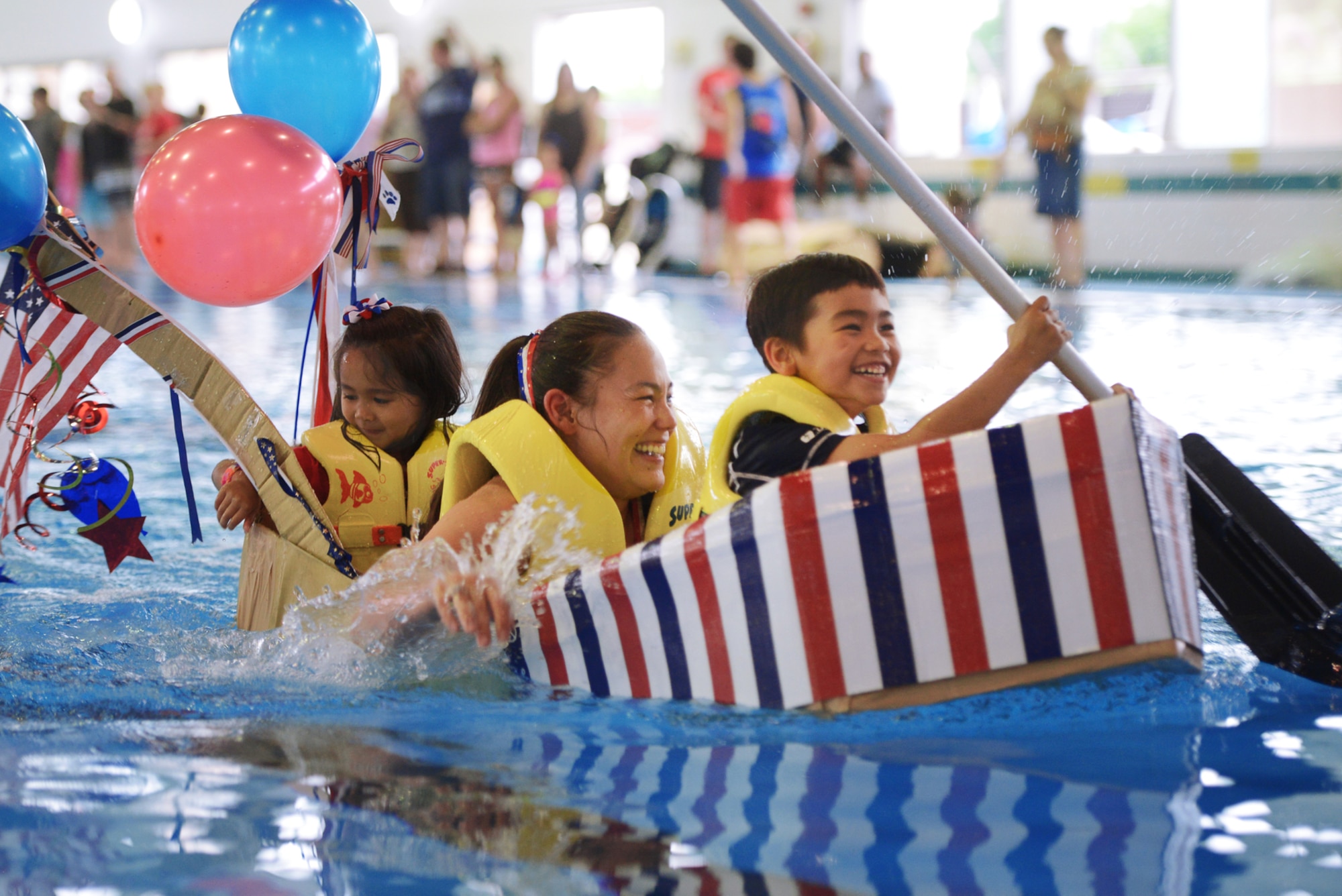 A family races to victory in the Leaky Kon Tiki race during Celebrate America at Yokota Air Base, Japan, July 2, 2015. The race, hosted by the 374th Force Support Squadron, was one of many events held during Celebrate America. (U.S. Air Force photo by Airman 1st Class Delano Scott/Released)