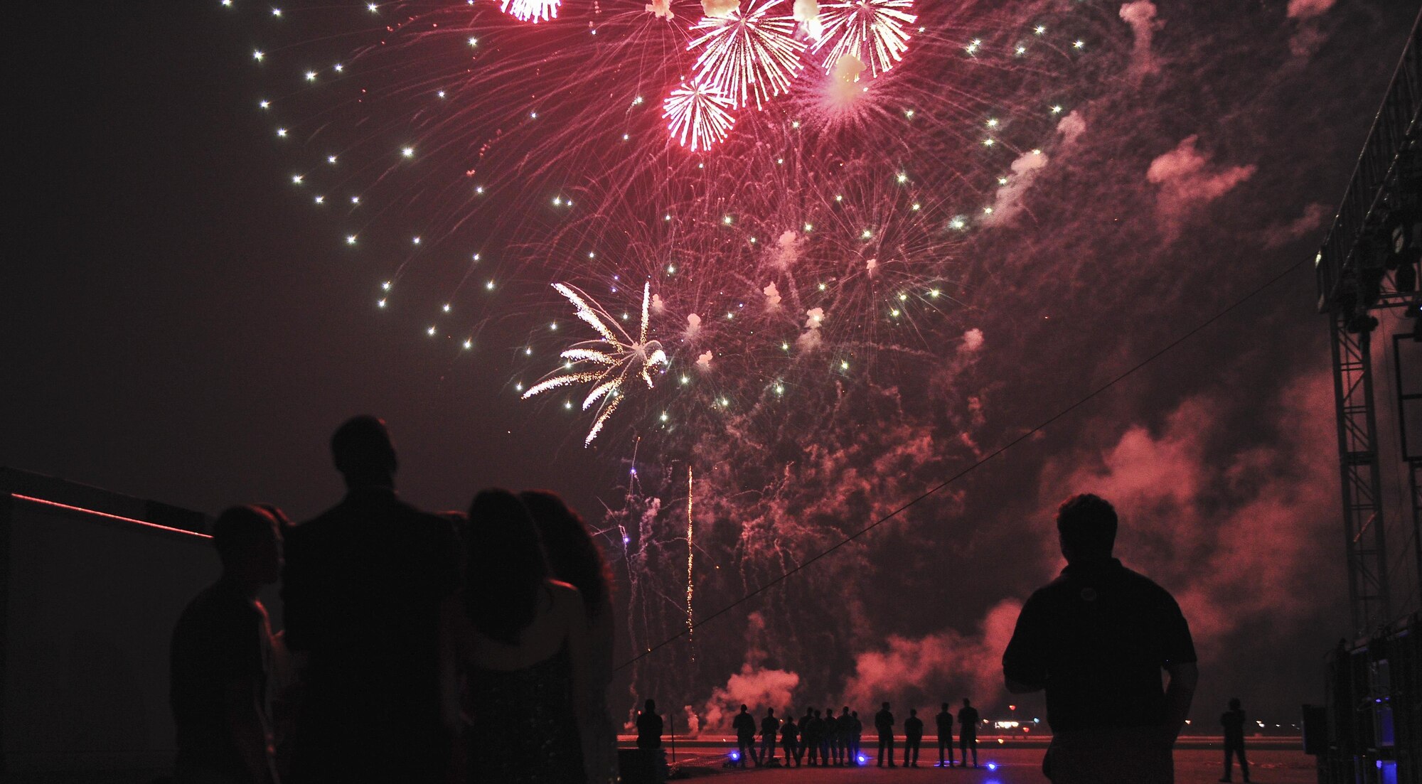 Airmen and entertainers gaze as the fireworks ignite over the skies Osan Air Base, Republic of Korea, July 4, 2015, in celebration of Independence Day. The fireworks presentation was one of the last displays of entertainment for a crowd of more than 5,000 during the festival. (U.S. Air Force photo/Tech. Sgt. Travis Edwards)