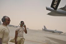 Technical Sgt. Ellison Cason and Airman 1st Class Marshawn Fry, 340th Expeditionary Aircraft Maintenance Unit, communicate to the pilots on wing flap mobility during pre-flight checks on a KC-135 Stratotanker June 7, 2015 Al Udeid Air Base, Qatar.