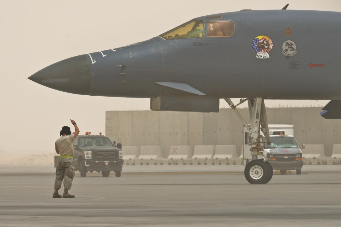 An airman from the 340th Expeditionary Aircraft Maintenance Unit directs a B-1 Lancer to the runway June 7, 2015 Al Udeid Air Base, Qatar.   
