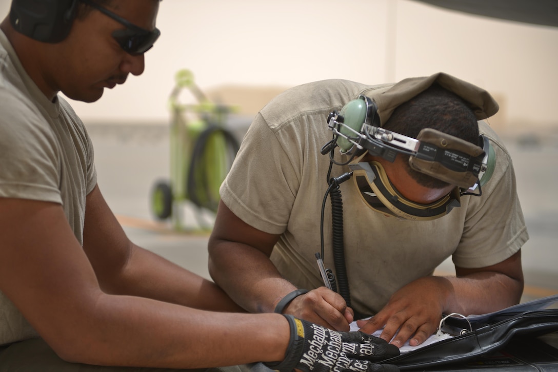 Airman 1st Class Jonathan Palacios-Conde and Senior Airman John Brown, 340th Expeditionary Aircraft Maintenance Unit, complete their post-flight checklist of a KC-135 Stratotanker June 7, 2015 Al Udeid Air Base, Qatar.   