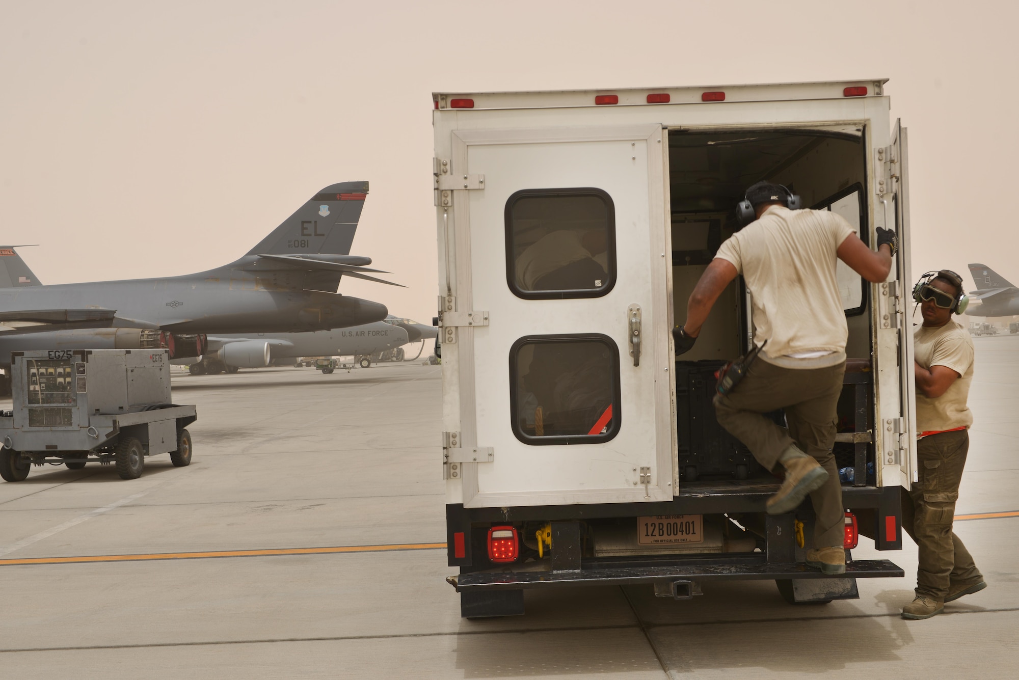 Airman 1st Class Jonathan Palacios-Conde and Senior Airman John Brown, 340th Expeditionary Aircraft Maintenance Unit, get in an airfield maintenance shuttle and prepare to service another aircraft for post-flight inspections June 7, 2015 Al Udeid Air Base, Qatar.   