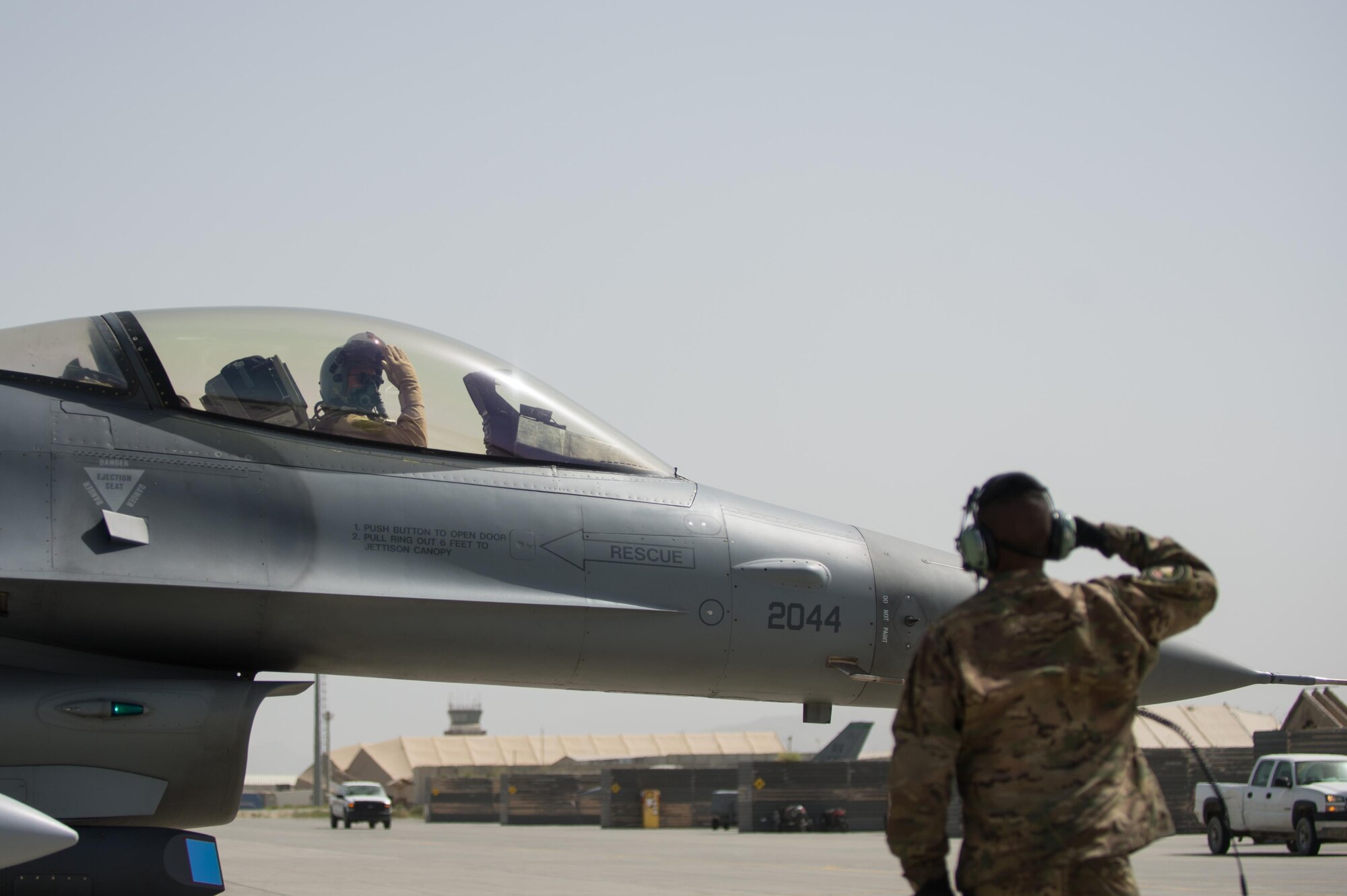 U.S. Air Force Brig. Gen. Dave Julazadeh, 455th Air Expeditionary Wing commander, salutes Airman 1st Class Manuel Jimenez, 455th Expeditionary Aircraft Maintenance Squadron crew chief, as he taxis an F-16 Fighting Falcon aircraft July 7, 2015, at Bagram Airfield, Afghanistan. Julazadeh was flying his first combat sortie as commander of the 455th AEW. (U.S. Air Force photo by Tech. Sgt. Joseph Swafford/Released)