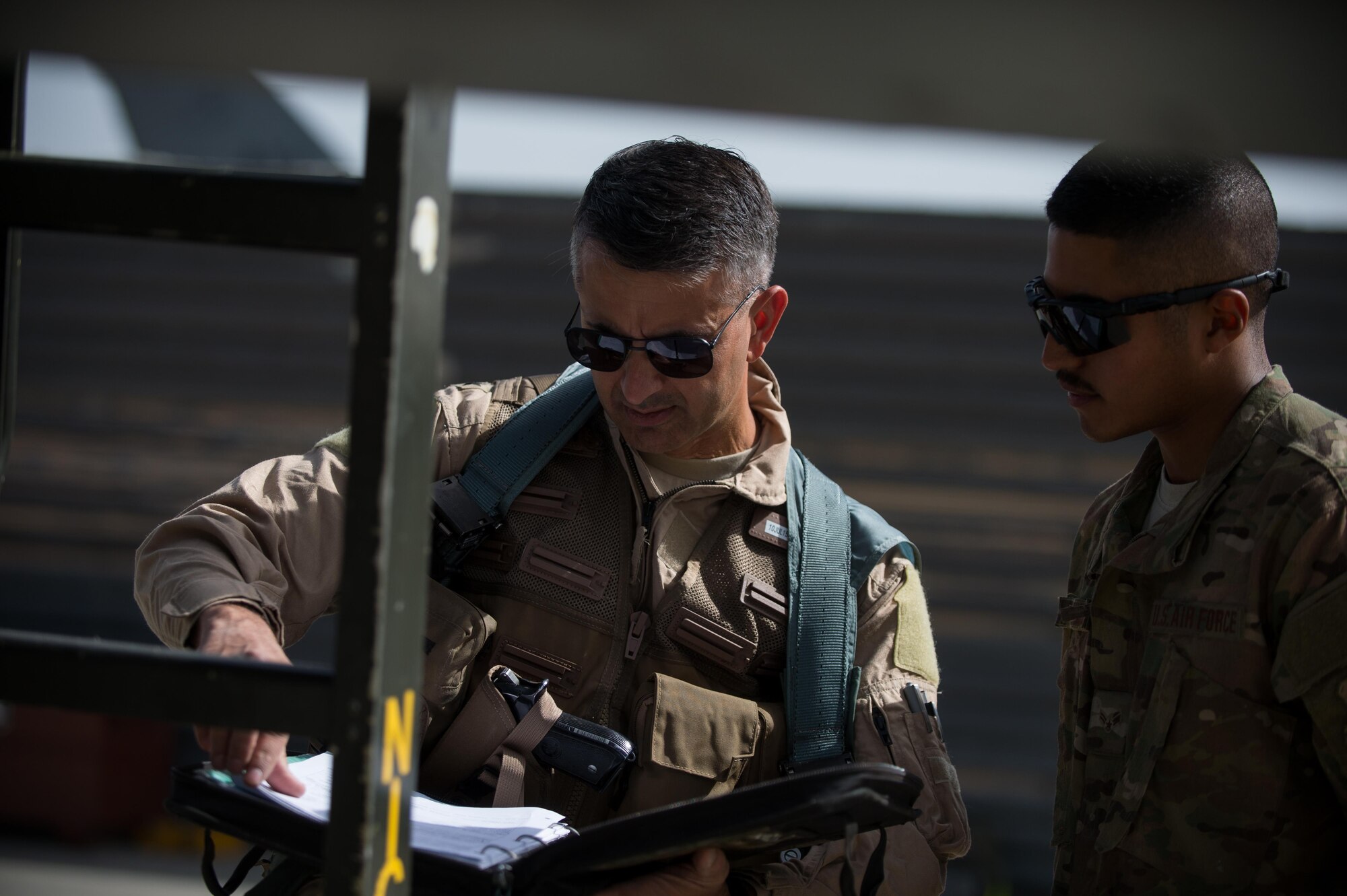 U.S. Air Force Brig. Gen. Dave Julazadeh, 455th Air Expeditionary Wing commander, and Airman 1st Class Manuel Jimenez, 455th Expeditionary Aircraft Maintenance Squadron crew chief, go over F-16 Fighting Falcon aircraft preflight procedures at Bagram Airfield, Afghanistan, July 7, 2015. Julazadeh was flying his first combat sortie as commander of the 455th AEW. (U.S. Air Force photo by Tech. Sgt. Joseph Swafford/Released)