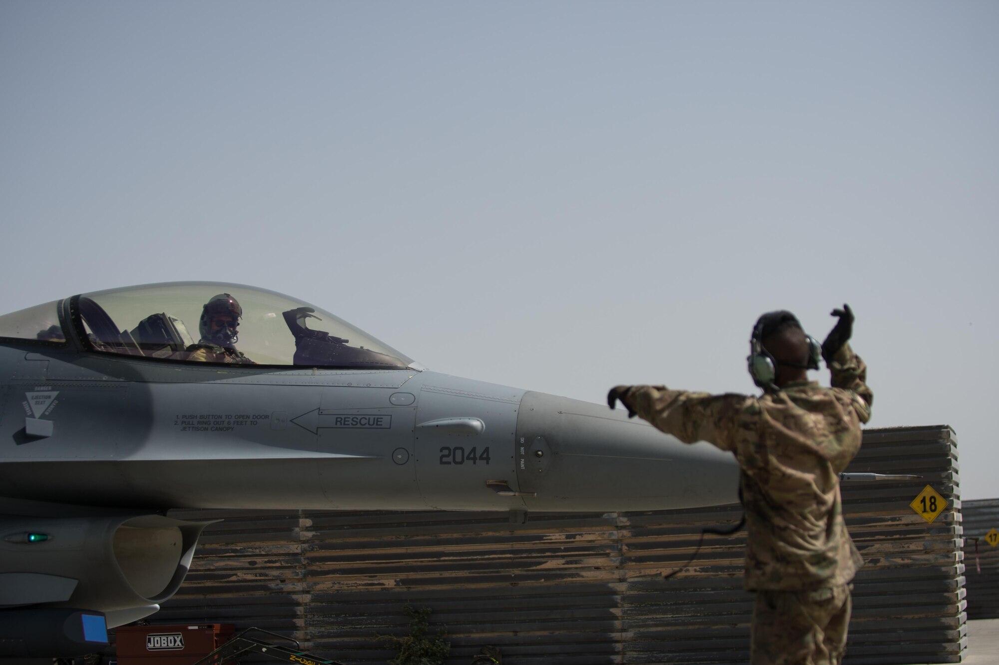 U.S. Air Force Airman 1st Class Manuel Jimenez, 455th Expeditionary Aircraft Maintenance Squadron crew chief, spots Brig. Gen. Dave Julazadeh, 455th Air Expeditionary Wing commander, as he taxis an F-16 Fighting Falcon aircraft July 7, 2015, at Bagram Airfield, Afghanistan. Julazadeh was flying his first combat sortie as commander of the 455th AEW. (U.S. Air Force photo by Tech. Sgt. Joseph Swafford/Released)