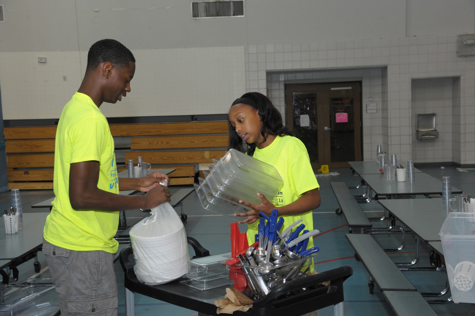 JeVaughnte Shannon (left) and MeMe Hartson, Joint Base San Antonio-Randolph Youth Center Youth Employment Skills program participants, prepare to set up tables for lunch June 22 at the JBSA-Randolph Youth Center.
