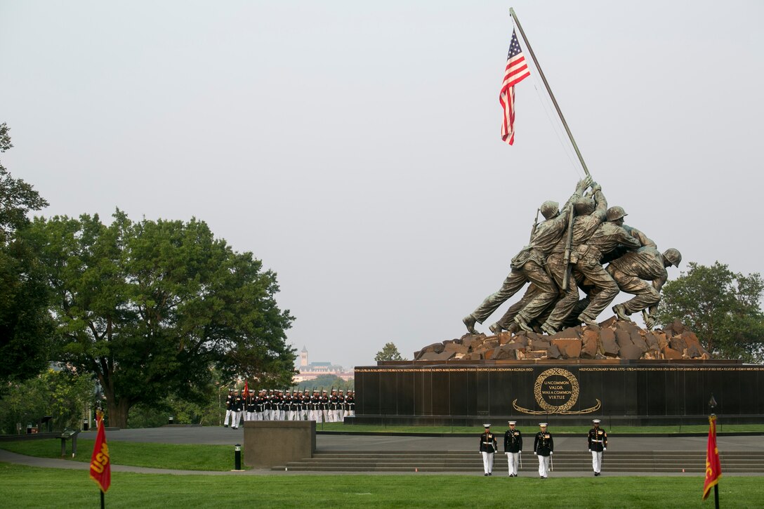 The parade staff performs during the Sunset Parade at the Marine Corps War Memorial in Arlington, Va., July 7, 2015. Medal of Honor recipient Hershel Woodrow "Woody" Williams was the guest of honor for the Sunset Parade and the deputy commandant of plans, policies and operations, Lt. Gen. Ronald L. Bailey was the hosting official for that same parade. Williams is the last surviving Medal of Honor recipient from the battle of Iwo Jima, World War II. (U.S. Marine Corps photo by Cpl. Christian Varney/Released)