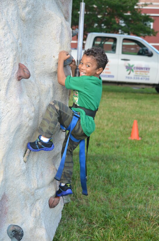 Ezra, 4, is having a great time on the climbing wall that was set up on Lejeune Field for the Independence Day celebration.