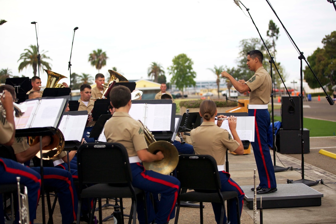 U.S. Marine Corps Gunnery Sgt. Christian A. Arellano, assigned to 12th Marine Corps District, performs as conductor during a concert hosted by Brig. Gen. James W. Bierman, Commanding General of Marine Corps Recruit Depot (MCRD) San Diego and the Western Recruiting Region, at MCRD San Diego, Calif., June 27, 2015. Arellano, a musician recruiter and instructor, was invited to conduct the last three pieces played during the 2015 Summer Concert. (U.S. Marine Corps photo by Lance Cpl. Bethanie C. Sahms/Released)