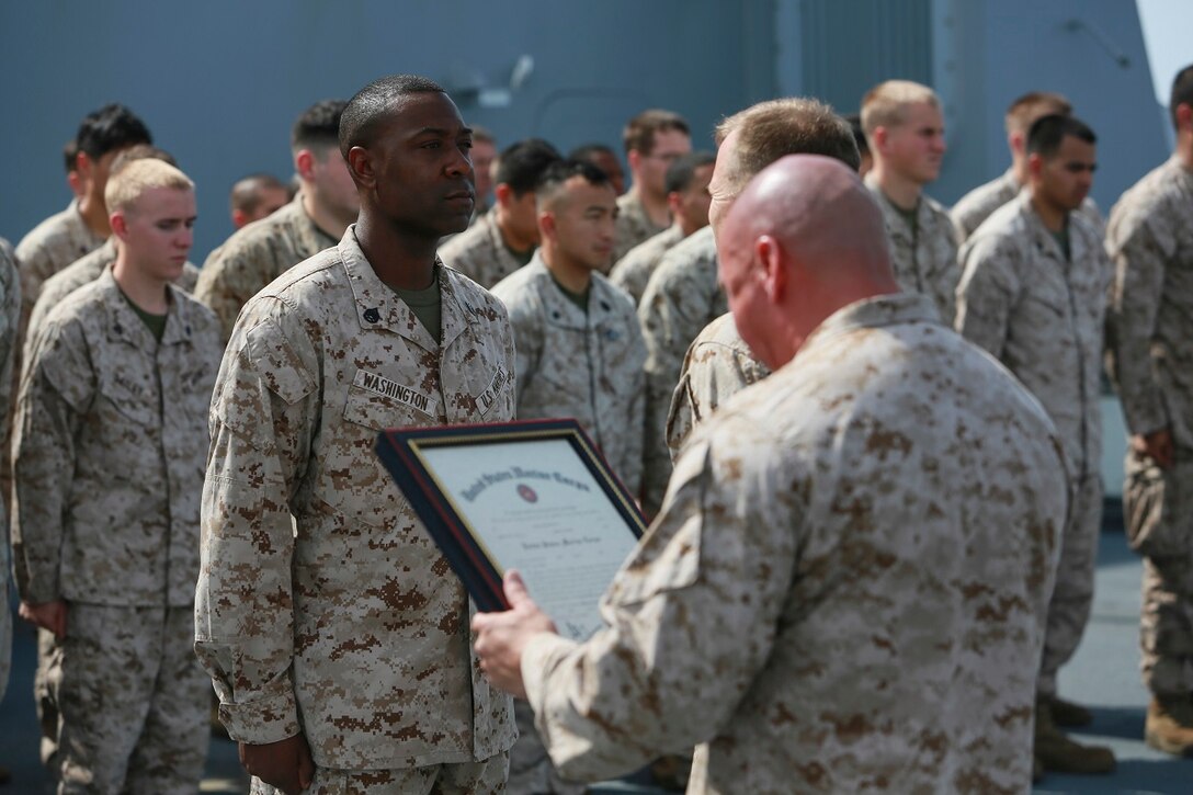 GULF OF ADEN (July 1, 2015) U.S. Marine Gunnery Sgt. Michael Washington, left, reports to Lt. Col. Edward C. Greeley during his promotion ceremony on the forecastle of the amphibious transport dock ship USS Anchorage (LPD 23). Washington is the company gunnery sergeant for Headquarters and Service Company, Battalion Landing Team 3rd Battalion, 1st Marine Regiment, 15th Marine Expeditionary Unit. Anchorage is part of the Essex Amphibious Ready Group and, with the embarked 15th Marine Expeditionary Unit, is deployed in support of maritime security operations and theater security cooperation efforts in the U.S. 5th Fleet area of operations.  (U.S. Marine Corps photo by Sgt. Steve H. Lopez/ Released)