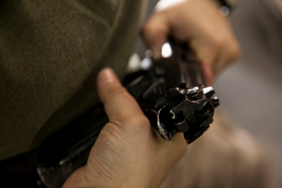 A U.S. Marine with the 15th Marine Expeditionary Unit practices handling the M9 Beretta pistol during a female engagement team class aboard the amphibious assault ship USS Essex (LHD 2). The Marines are participating in a week-long screener to assess their knowledge of skills such as marksmanship, detainee handling, patrolling, and teaching skills. The 15th MEU is embarked on the Essex Amphibious Ready Group and deployed to maintain regional security in the U.S. 5th Fleet area of operations. (U.S. Marine Corps photo by Cpl. Elize McKelvey/ Released)