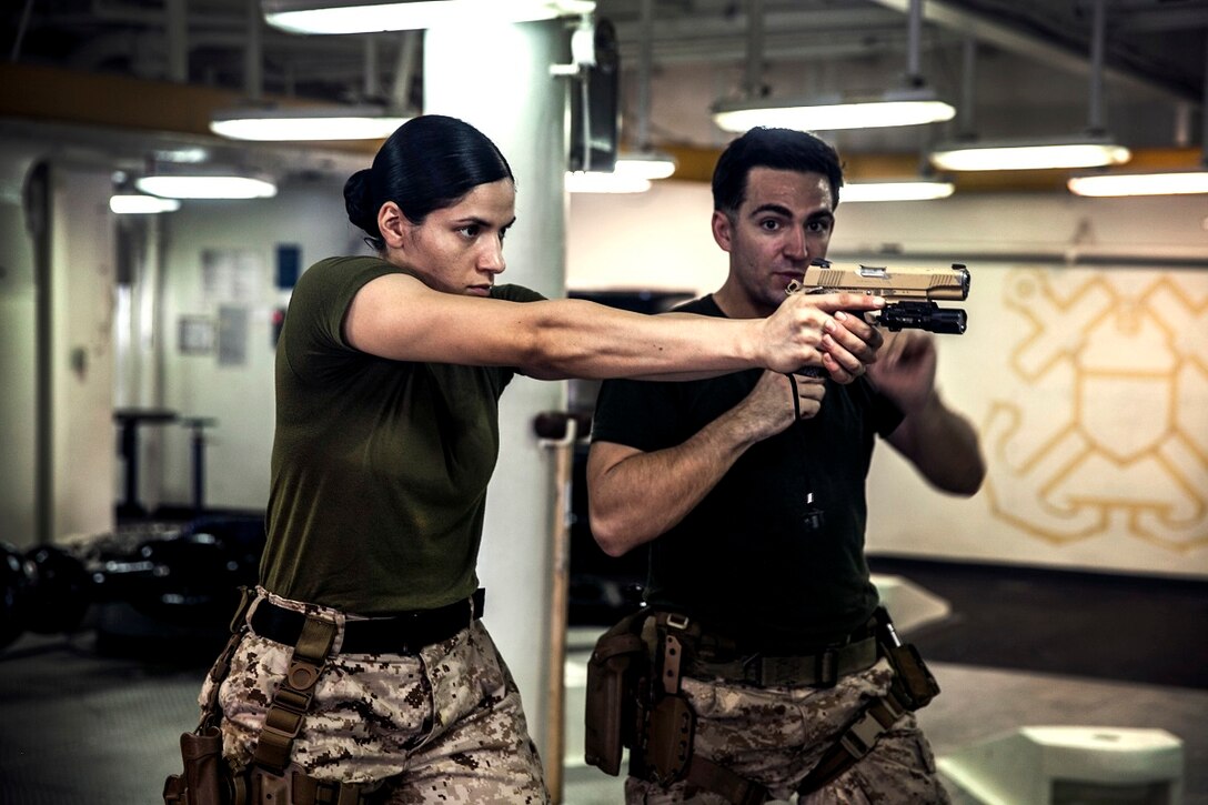 U.S. Marine Sgt. Jeanette Ventura, left, receives instruction from Sgt. Sean Bernstein on handling techniques for the M45 1911 A1 pistol during a female engagement team class aboard the amphibious assault ship USS Essex (LHD 2). Ventura is an airframe mechanic with the Medium Tiltrotor Squadron 161 (Reinforced), 15th Marine Expeditionary Unit and Bernstein is a member of the 15th MEU’s Maritime Raid Force. The Marines are participating in a week-long screener to assess their knowledge of skills such as marksmanship, detainee handling, patrolling, and teaching skills. The 15th MEU is embarked on the Essex Amphibious Ready Group and deployed to maintain regional security in the U.S. 5th Fleet area of operations. (U.S. Marine Corps photo by Cpl. Elize McKelvey/ Released)