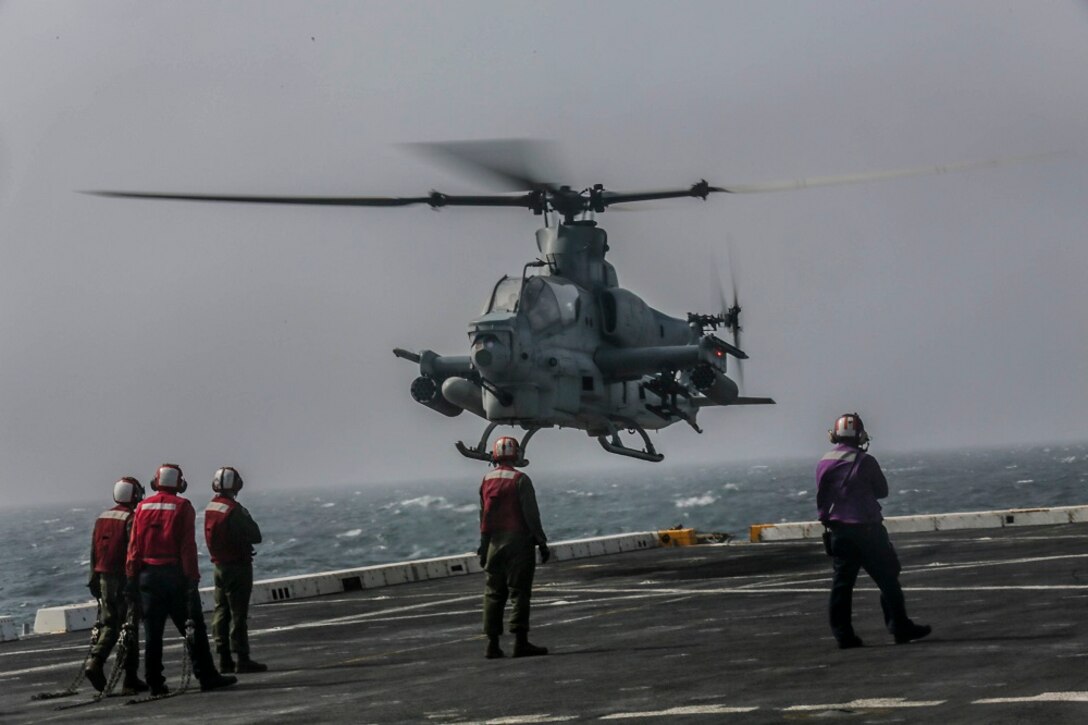 ARABIAN SEA (July 6, 2015) U.S. Marines and Sailors prepare to receive an AH-1Z Viper from the “Greyhawks” of Marine Medium Tiltrotor Squadron 161 (Reinforced), 15th Marine Expeditionary Unit, during flight quarters aboard the amphibious transport dock USS Anchorage (LPD 23).  The “Greyhawks” are the air combat element of the 15th MEU, and embarked aboard the ships of the Essex Amphibious Ready Group, are deployed in support of maritime security operations and theater security cooperation efforts in the U.S. 5th Fleet area of operations. (U.S. Marine Corps photo by Sgt. Jamean Berry/ Released)