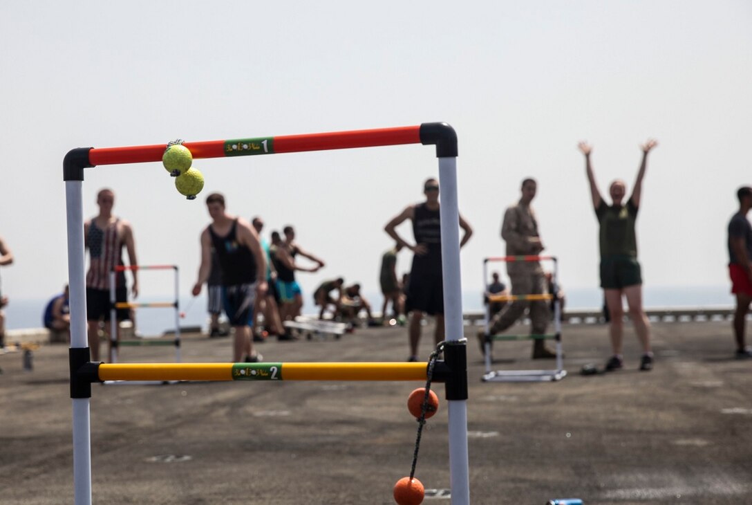 GULF OF ADEN (July 4, 2015) U.S. Marines and Sailor with the 15th Marine Expeditionary Unit and Essex Amphibious Ready Group, celebrate after a successful throw during a game of “ladders” during a steel beach picnic on the flight deck of the amphibious assault ship USS Essex (LHD 2). The event built morale among the 15th MEU and with Sailors from the Essex ARG. The 15th MEU is embarked on the Essex ARG and deployed to maintain regional security in the U.S. 5th Fleet area of operations. (U.S. Marine Corps photo by Cpl. Elize McKelvey/Released)