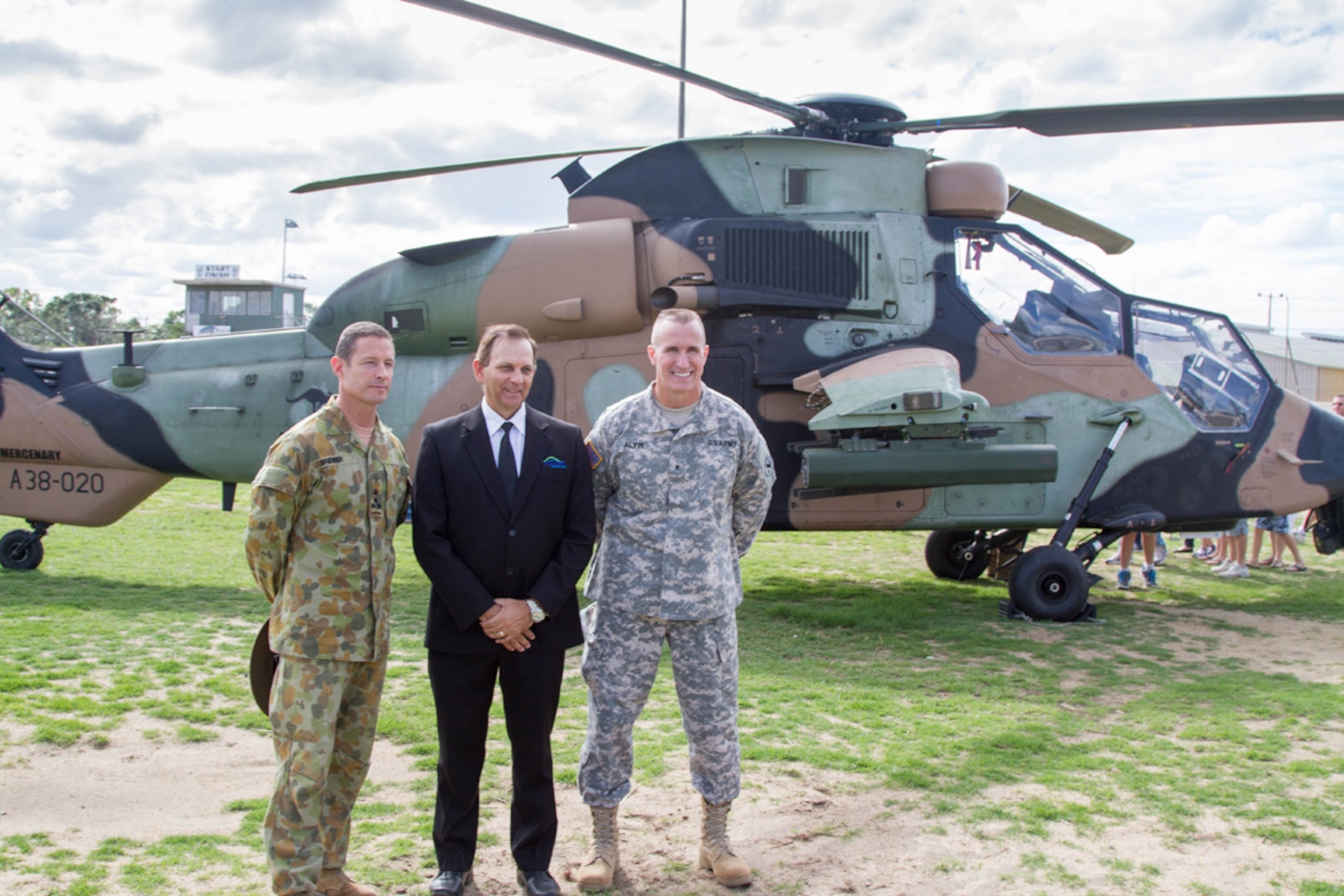 ROCKHAMPTON, Australia (July 6, 2015) - Australian Brigadier Mark Brewer (Left), Deputy Mayor of Rockhampton Tony Williams (Center), and U.S. Army Brigadier General Brian Alvin pose for a photo in front of an Australian Tiger Attack Helicopter during the Exercise Talisman Sabre 15 Open Day Ceremony. The event had service members from U.S., Australian and New Zealand militaries, static displays, military history re-enactors and cultural displays. The exercise is a biennial event where all militaries practice their interoperability skill and to strengthen the partnership between the forces. 