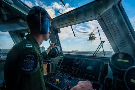 TIMOR SEA (July 7, 2015) - Lt. j.g. Rodney Waggstaff, landing safety officer from the "Saberhawks" of Helicopter Maritime Strike Squadron (HSM) 77, directs an MH-60R from the landing safety officer platform as it lands on the flight deck of the Ticonderoga-class guided-missile cruiser USS Antietam (CG 54) after conducting a Talisman Sabre 2015 (TS 15) anti-submarine warfare training exercise. TS15 is a bilateral training exercise intended to maintain a high level of interoperability between U.S. and Australian forces. 
