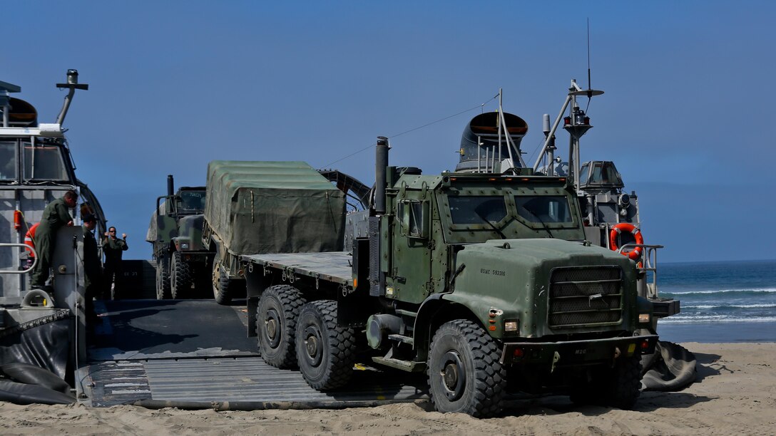 A Landing Craft Air Cushioned vehicle from Assault Craft Unit 5 unloads a Medium Tactical Vehicle Replacement onto Red Beach as part of a loading exercise along side Combat Logistics Battalion 11, Headquarters Regiment, 1st Marine Logistics Group, at Marine Corps Base Camp Pendleton, California, June 23, 2015. This loading exercise reinforces the Marine Corps' role as an amphibious force in readiness by maintaining capabilities through realistic training.