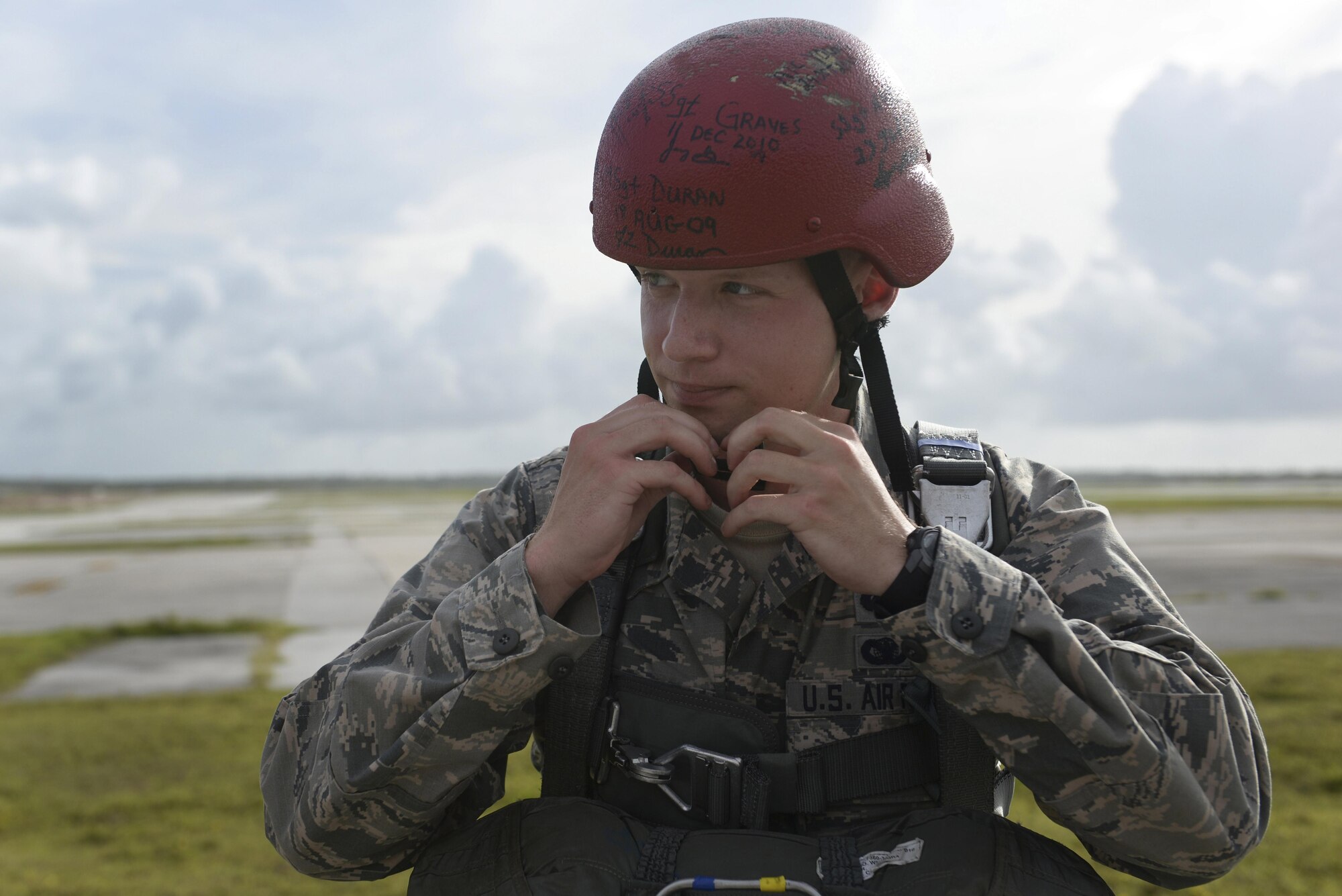 U.S. Air Force Capt. Justin Bateman, the 736th Security Forces Squadron director of operations, dons a red helmet prior to a static line parachute operation July 3, 2015, at Andersen Air Force Base, Guam. The red helmet identifies members who are performing their first jump after U.S. Army Basic Airborne School. Per tradition, Bateman signed the helmet after completing his jump. (U.S. Air Force photo by Senior Airman Katrina M. Brisbin/Released)