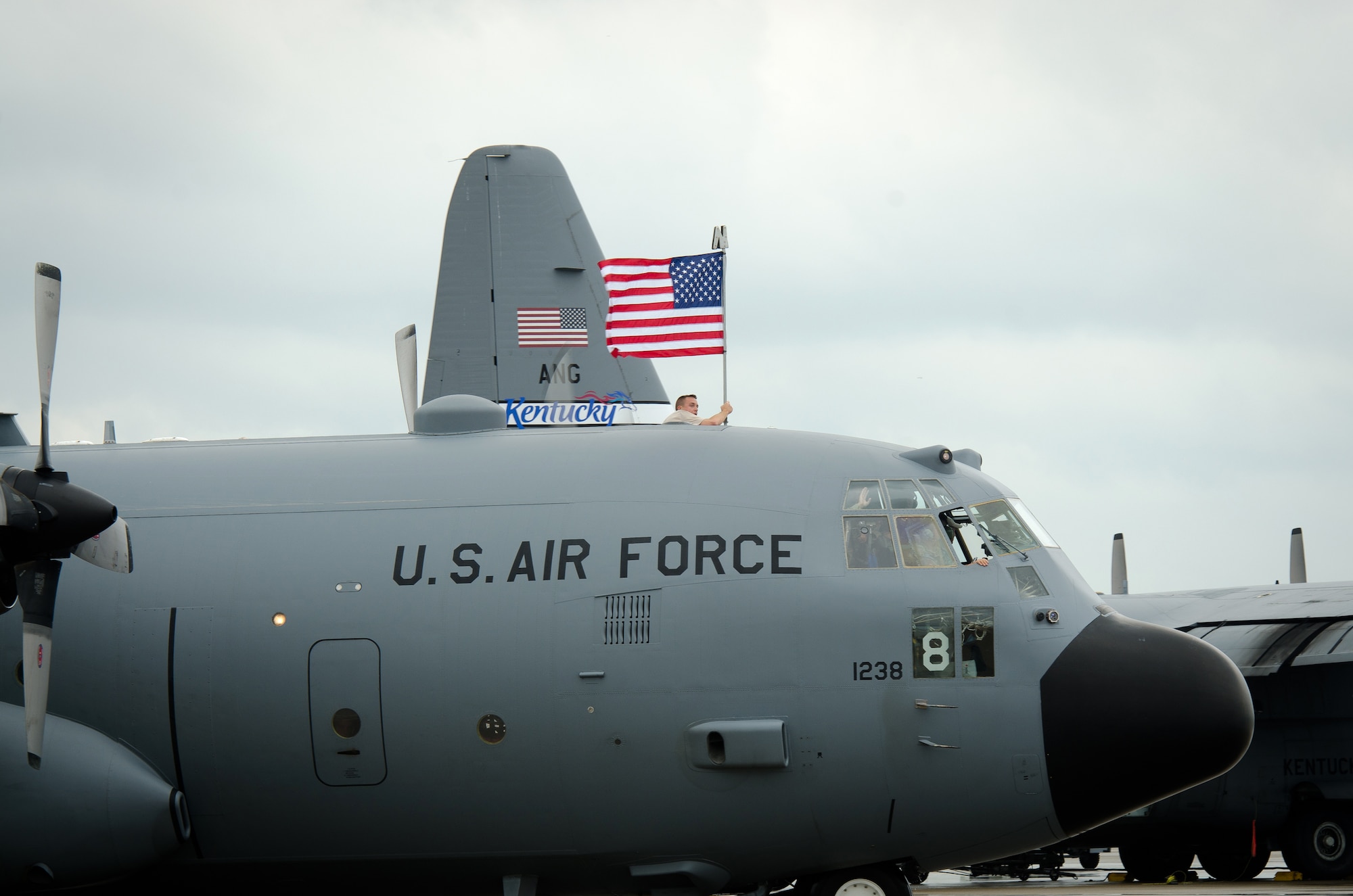 Tech. Sgt. David Clark, an aircrew flight equipment technician for the 123rd Airlift Wing, flies the American Flag atop a Kentucky Air Guard C-130 Hercules after landing for a homecoming ceremony at the Kentucky Air National Guard Base in Louisville, Ky., July 8, 2015. Thirty Kentucky Air Guardsmen returned from a deployment to the Persian Gulf Region, where they’ve been supporting Operation Freedom’s Sentinel since February. (U.S. Air National Guard photo by Master Sgt. Phil Speck)