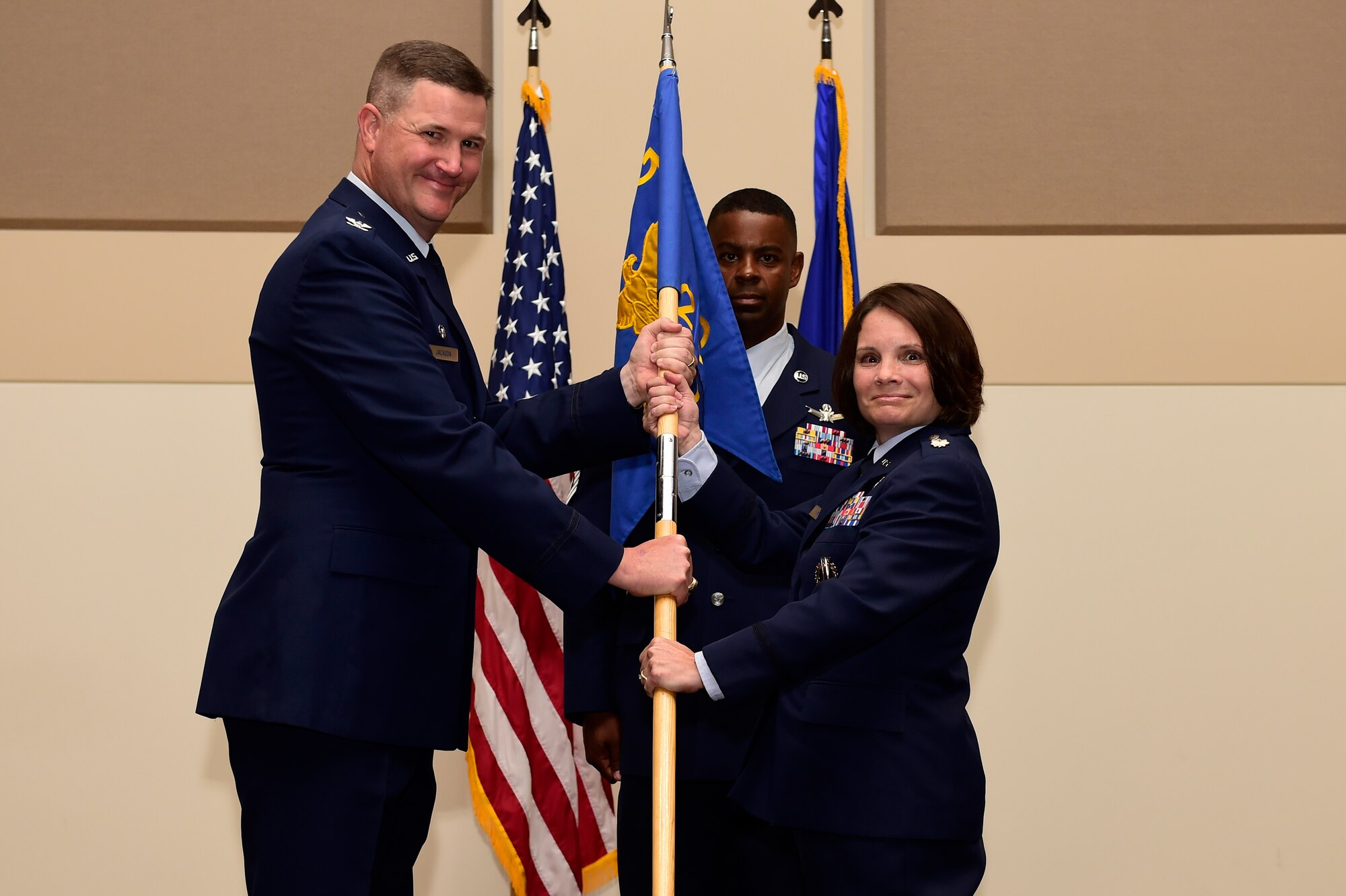 Col. Michael Jackson, 460th Operations Group commander, left; presents the 460th Space Wing guidon to Lt. Col. April Wimmer, right; symbolizing her assumption of command as the 2nd Space Warning Squadron commander July 7, 2015, on Buckley Air Force Base, Colo. Wimmer became the commander of the 2nd SWS after serving as the operations officer at the 533rd Training Squadron, Vandenberg AFB, Cali. (U.S. Air Force photo by Staff Sgt. Stephany Richards/Released)