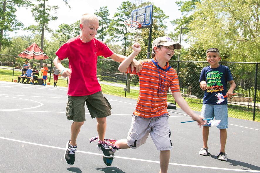 Logan Davis, left, son of U.S. Air Force Master Sgt. Jeremy Davis, 23d Equipment Maintenance Squadron, and Owen Kennedy, middle, son of Tech. Sgt. Dennis Kennedy, 476th Maintenance Squadron, run during a three-legged race during the July Jamboree, July 6, 2015, at Moody Air Force Base, Ga. The event focused on five categories consisting of promoting art, education, sports, health and life skills, and character and leadership. (U.S. Air Force photo by Airman Greg Nash/Released) 